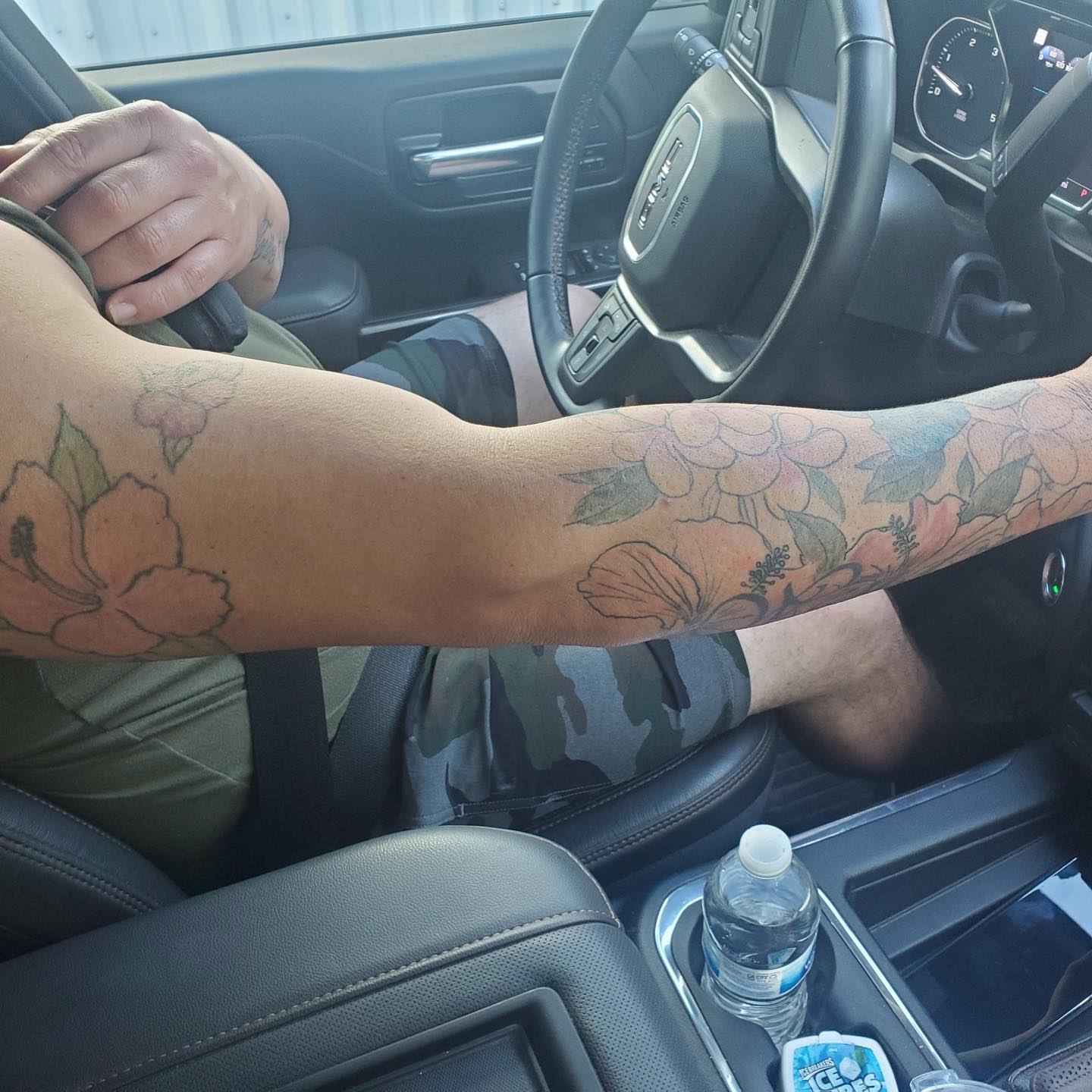 Floral arrangement black and grey tattoo on the forearm by Tattoos by Rey G.