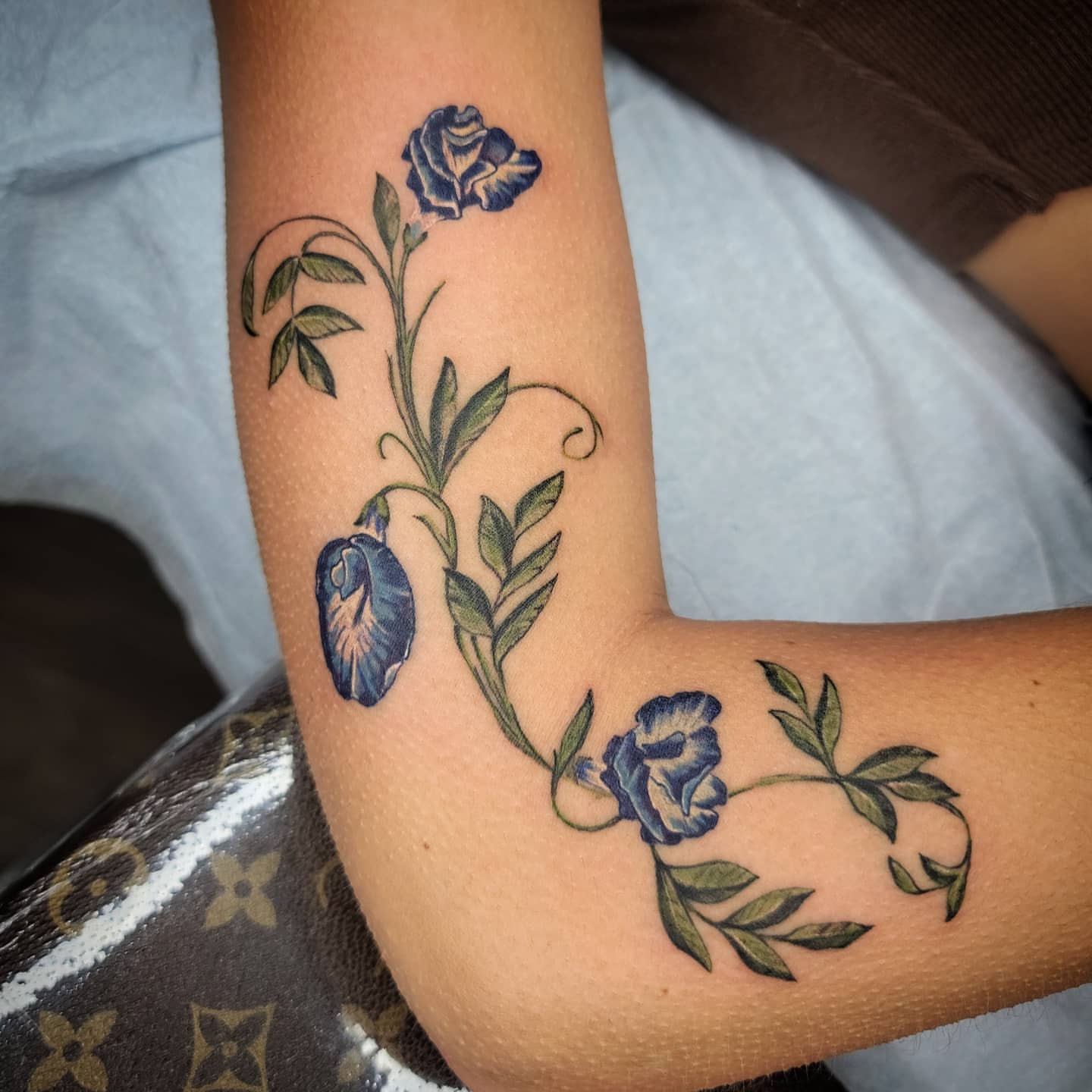 Blue pea flowers realism tattoo on the forearm by Shar - Utah Tattoo Artist