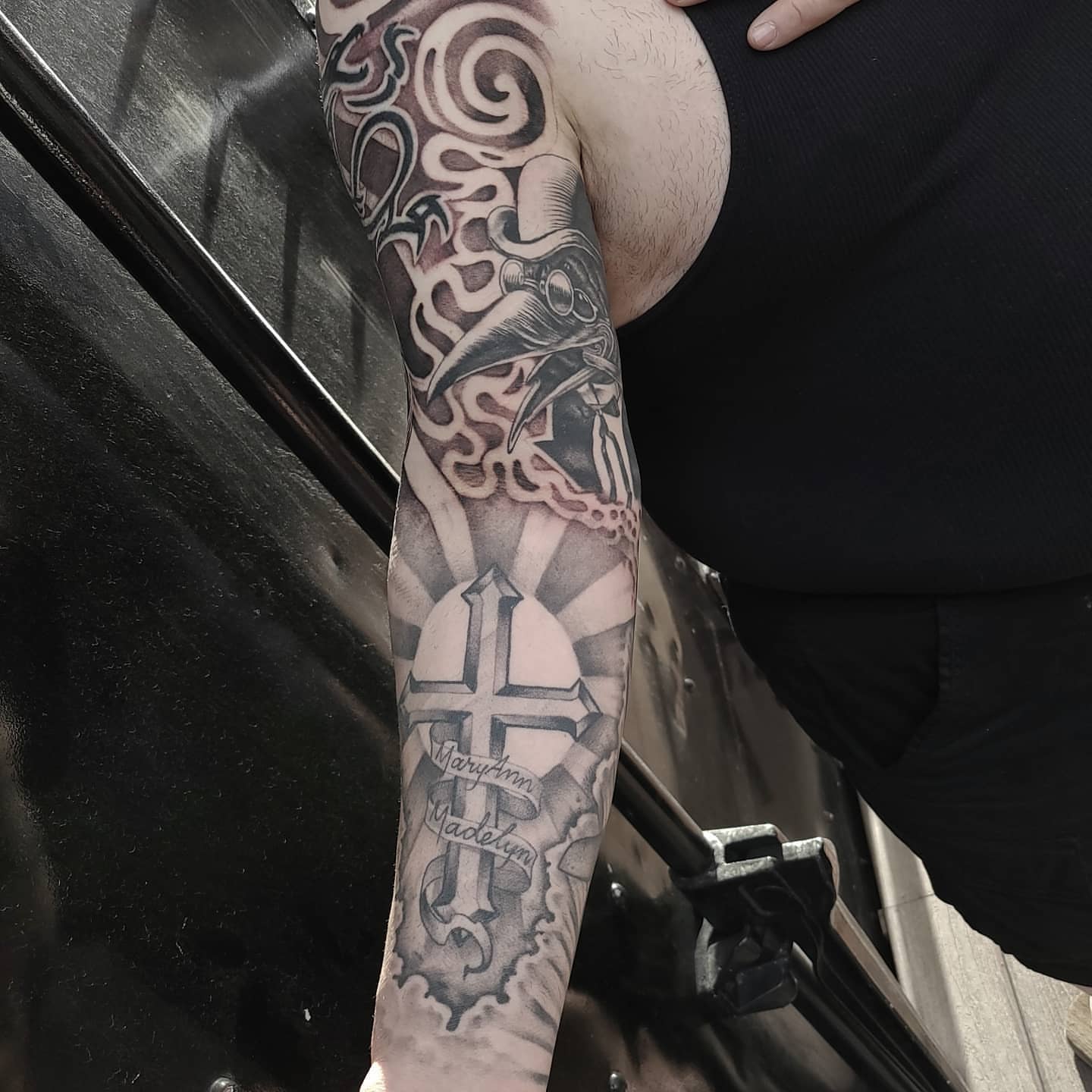 Cross and sunburst geometric tattoo on the forearm by Neri Gersaint
