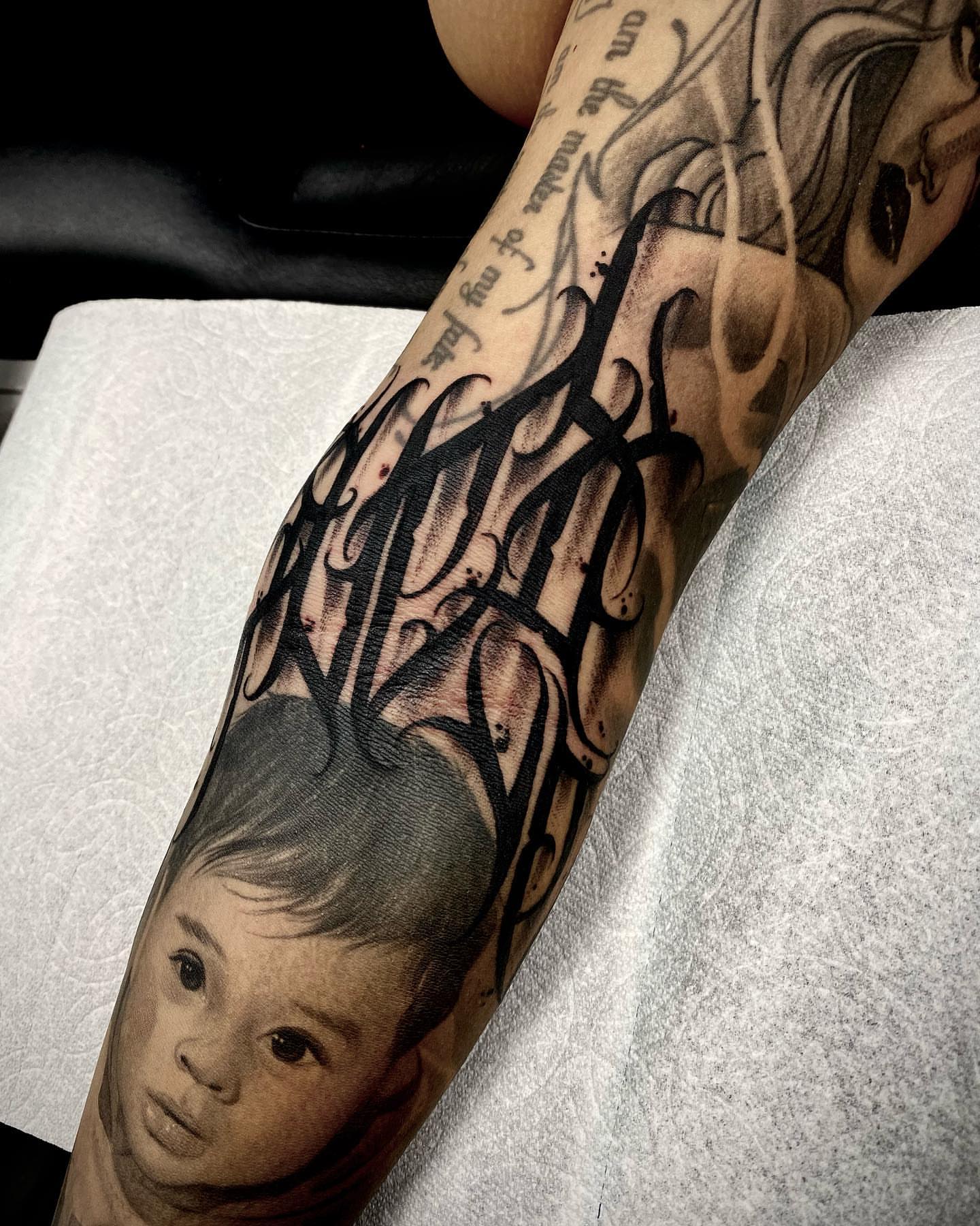 Child's face realism tattoo on the forearm by James Foltz