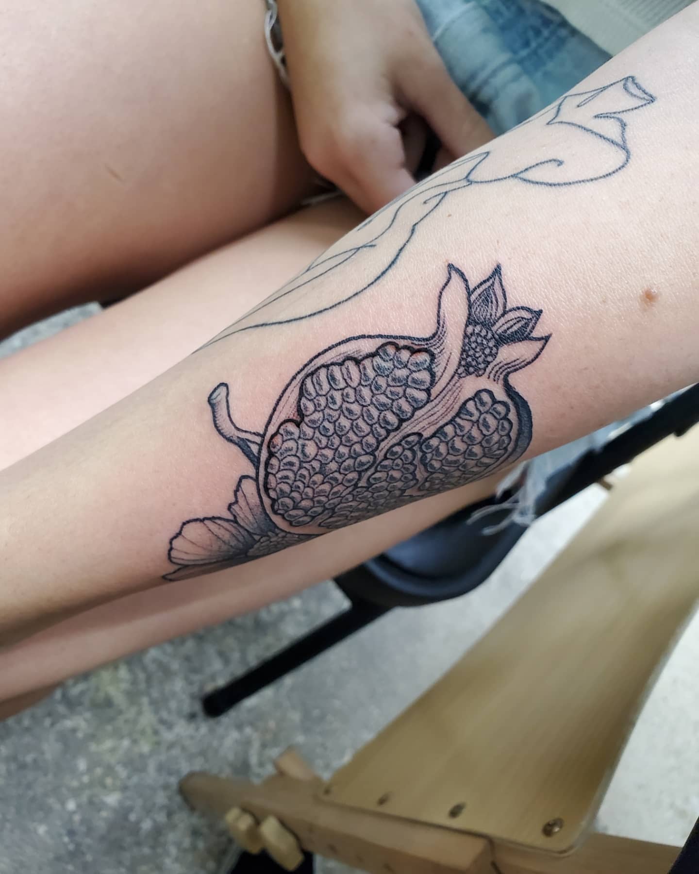Pomegranate black and grey tattoo on the forearm by Emily Jestine Francis