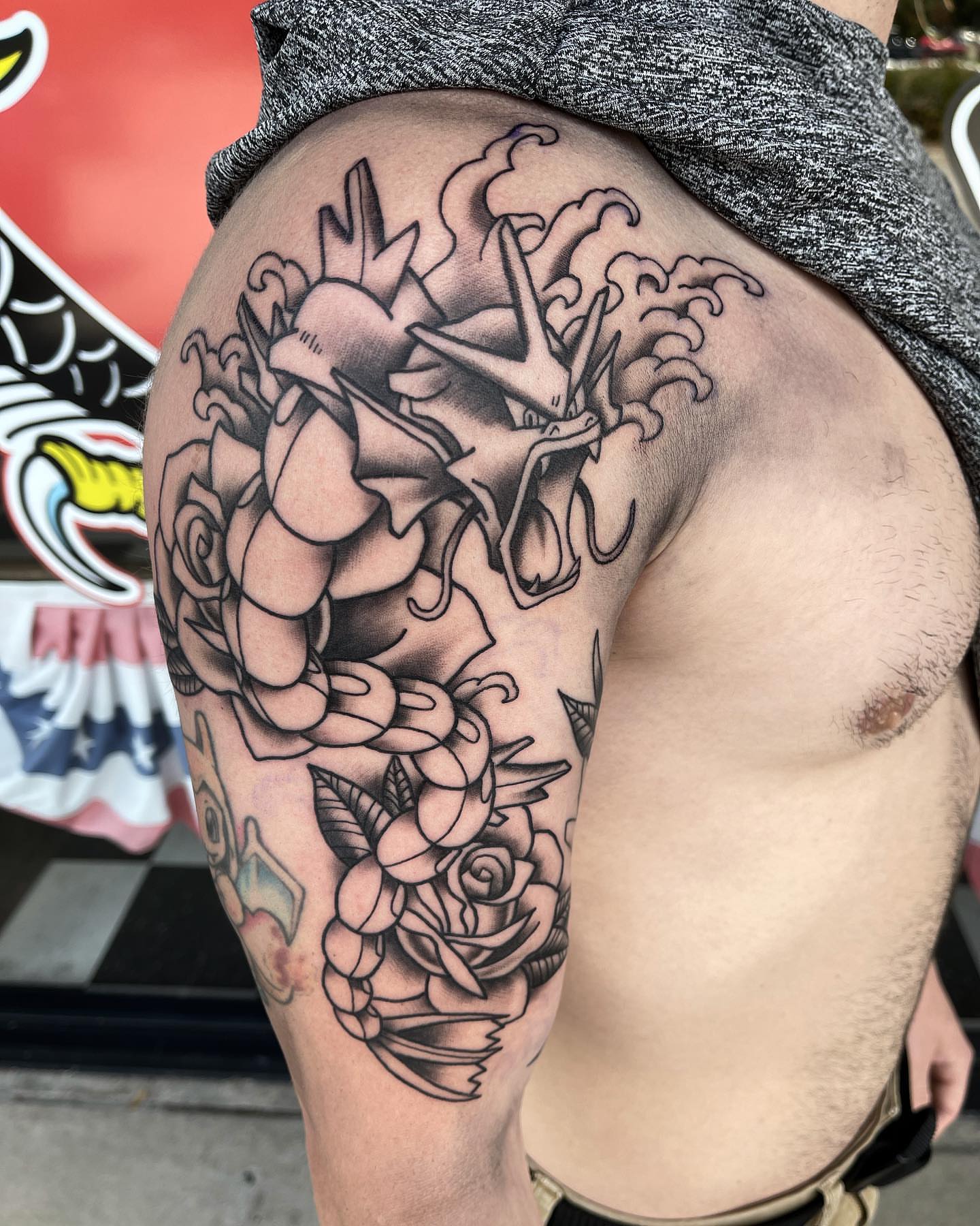 Dragon and roses black and grey tattoo on the thigh by Jake Snoddy, Franklin, Tennessee