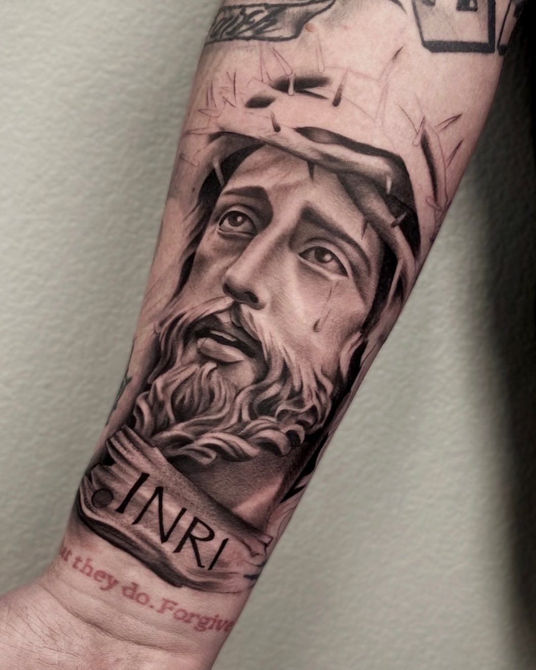 Religious figure realism tattoo on the forearm by Madison Ast Tattoo