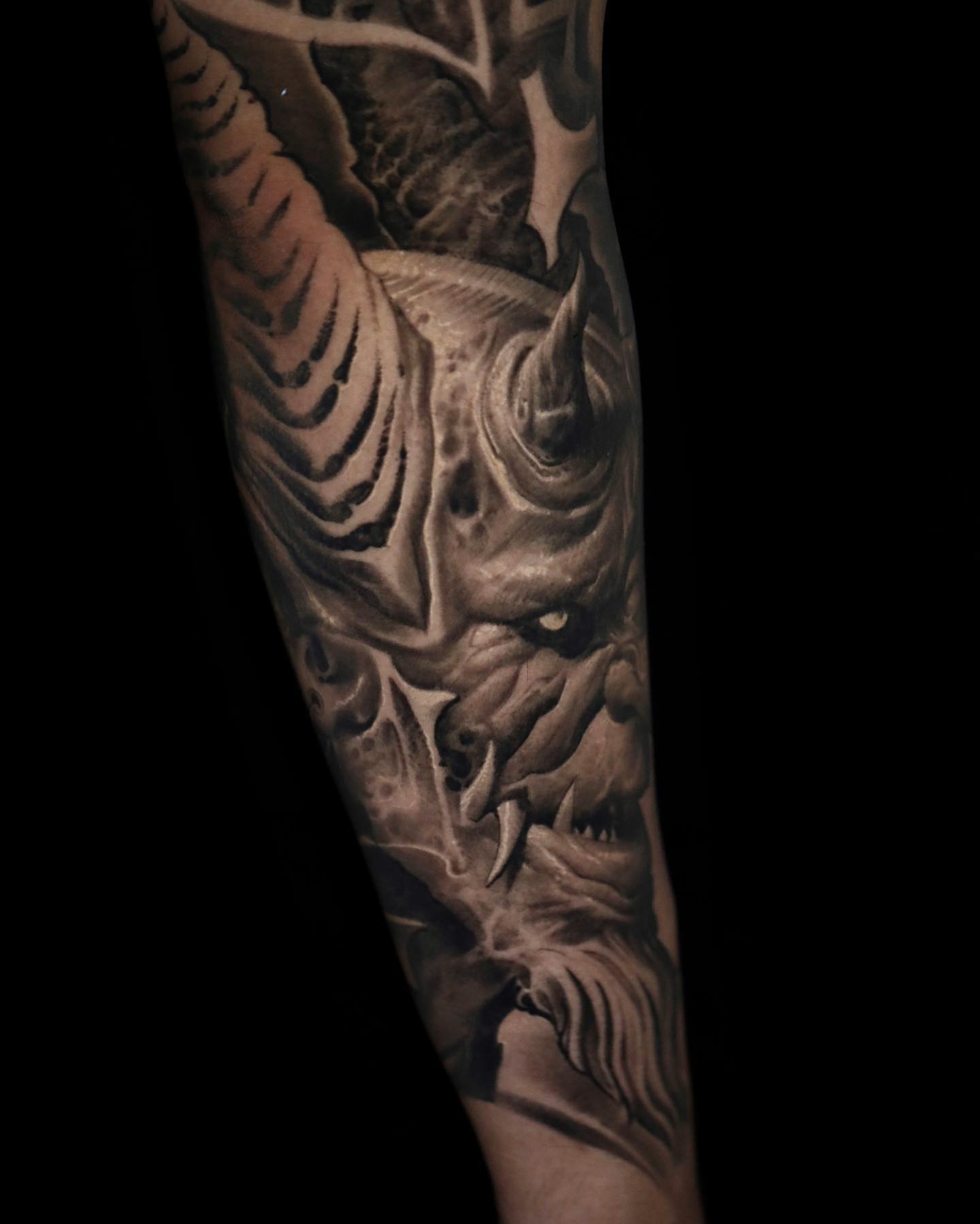 Demon face dark realism tattoo on the forearm by Victor Portugal Tattoo