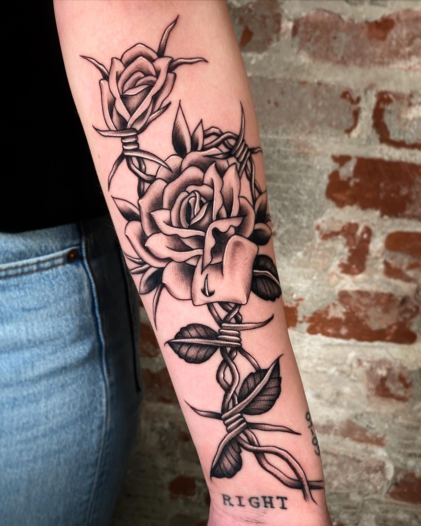 Roses entwined with string black and grey tattoo on the forearm by Nick Bridwell, Downey, California