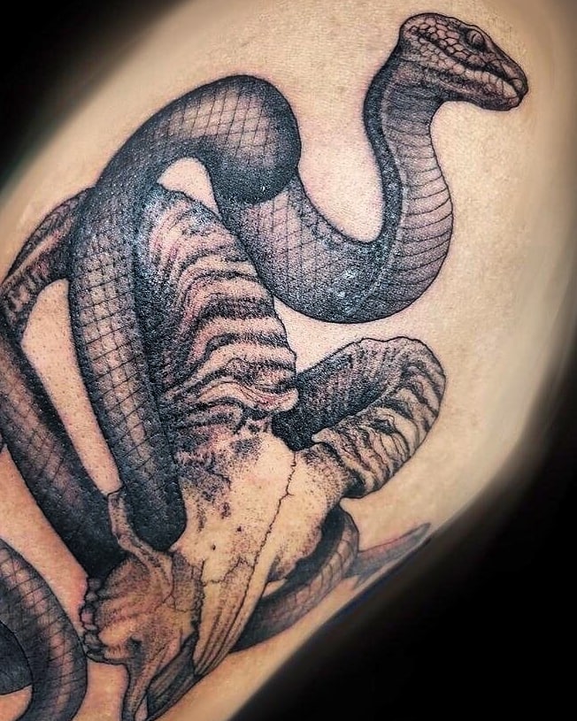 Snake black and grey tattoo on the shoulder by Emily Jestine Francis