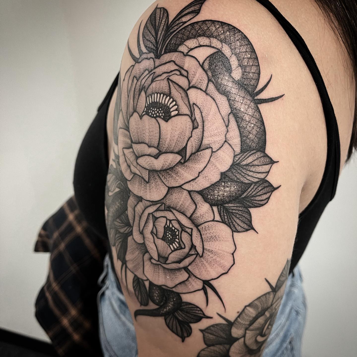 Snake and peony dotwork tattoo on the shoulder by Dale DeVille