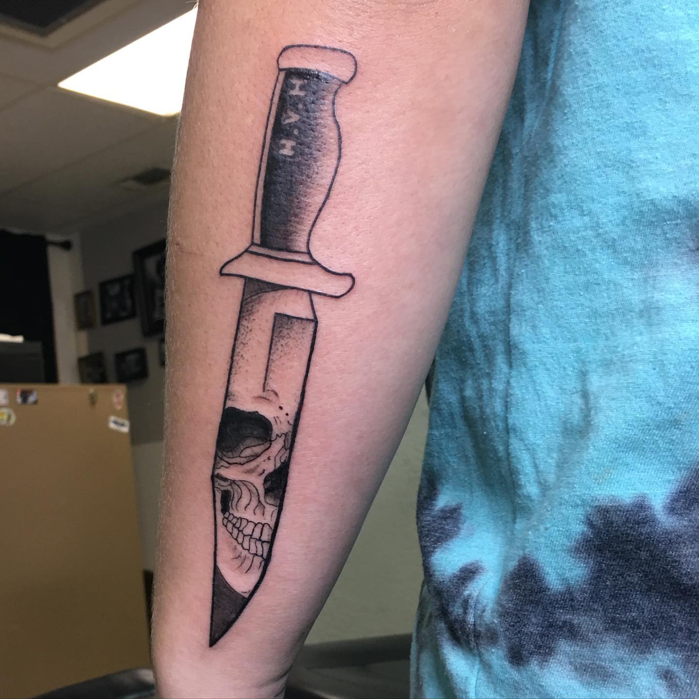Knife and skull realism tattoo on the forearm by Daphne Landry