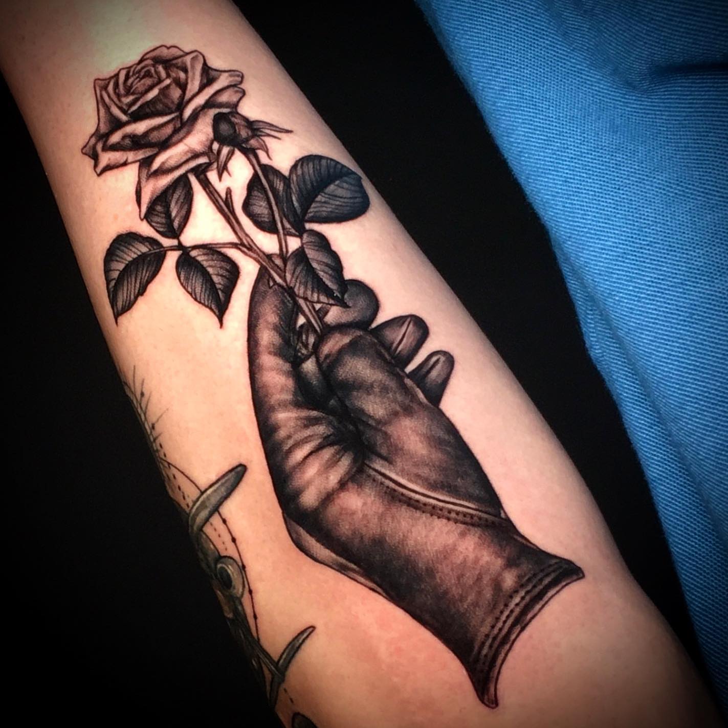 Rose and hand realism tattoo on the forearm by Ray Marie