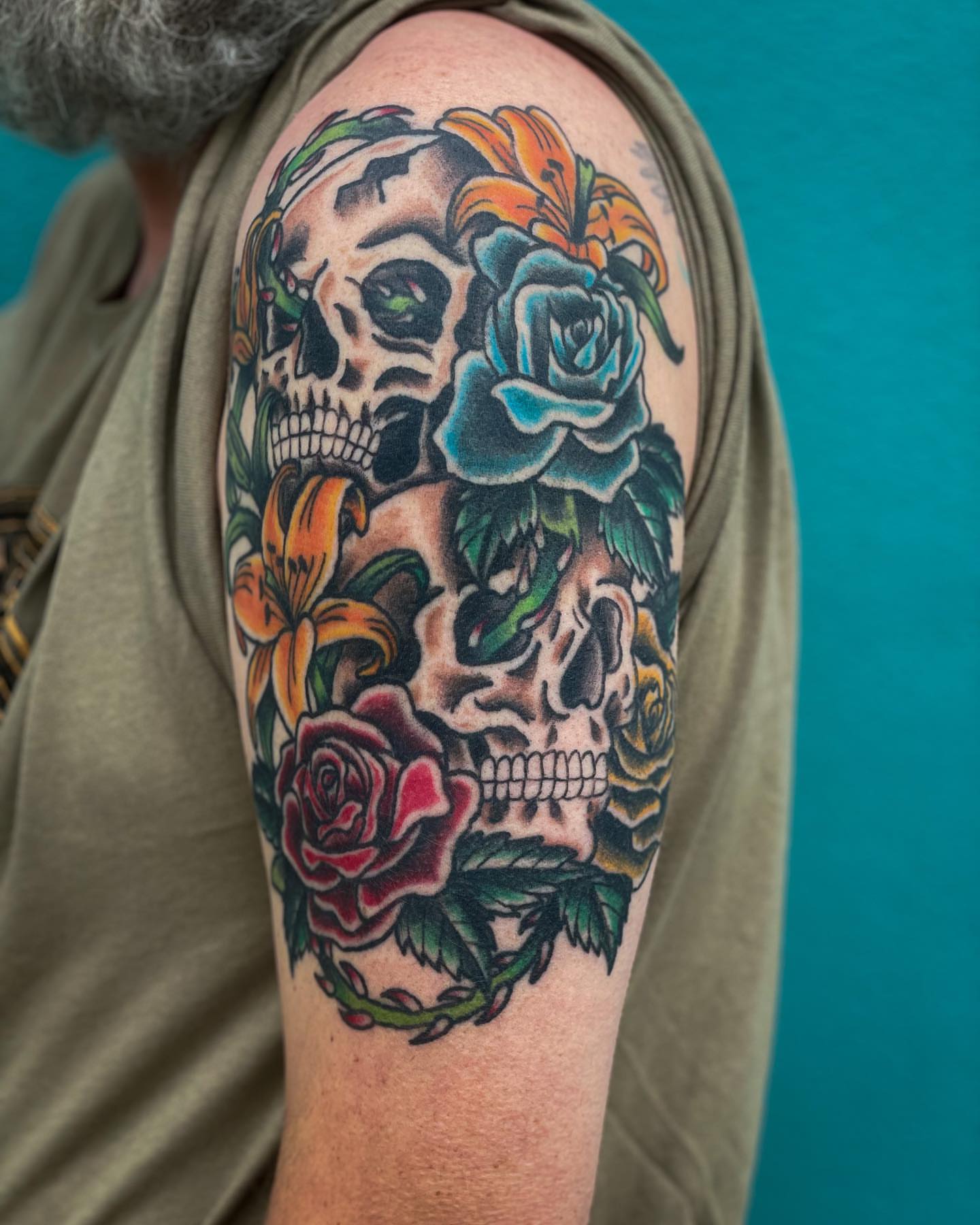 Skulls and roses American traditional tattoo on the shoulder by Erin Stephens