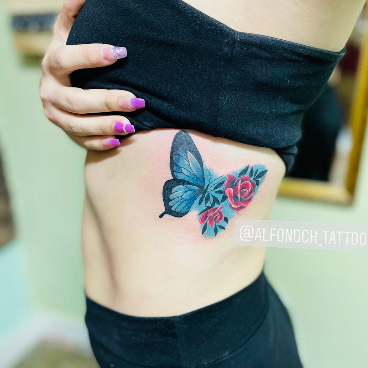 Butterfly and rose realism tattoo on the ribs by Alfonso Duenas