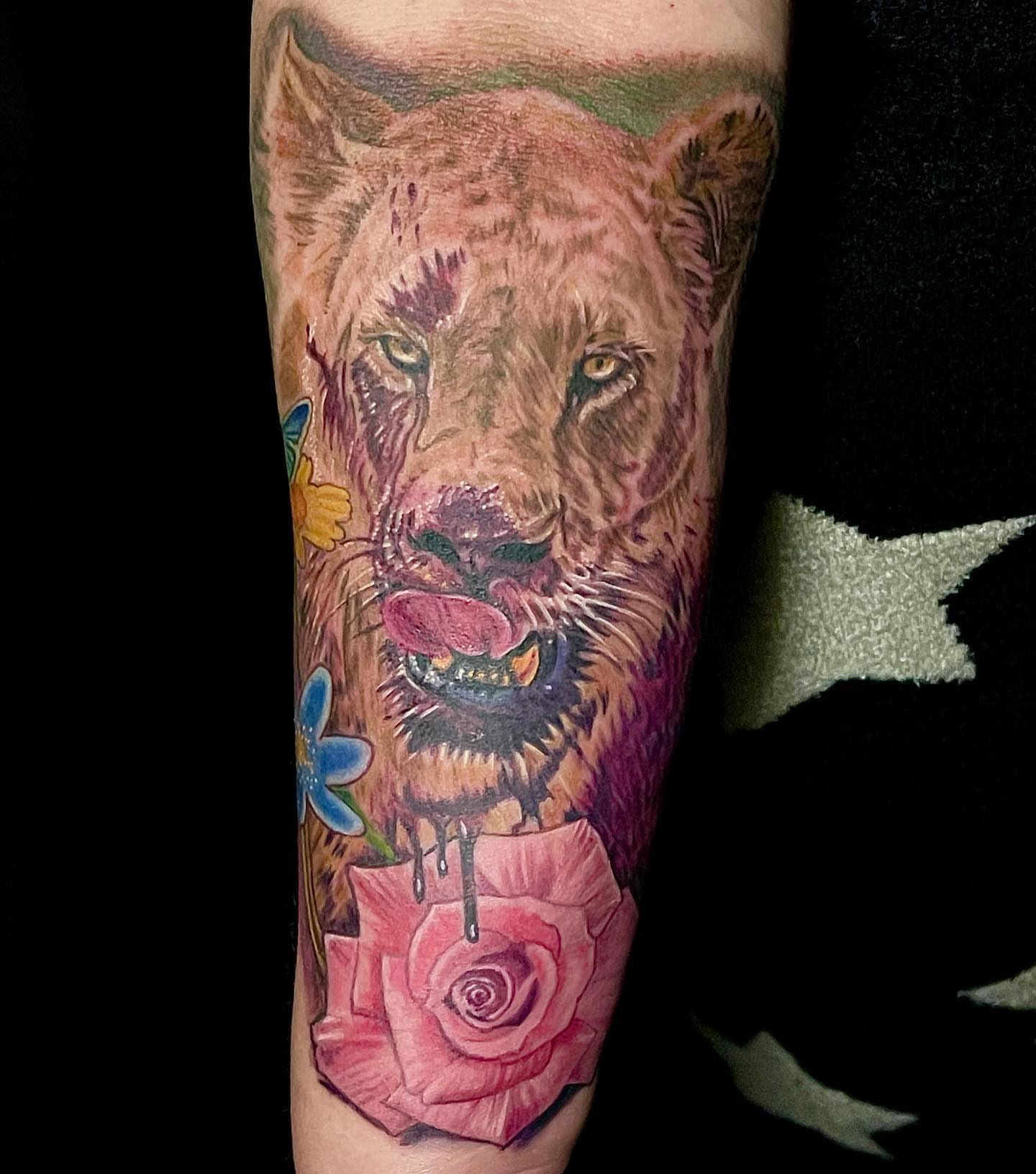 Lion with flowers realism tattoo on the forearm by Gary Graves
