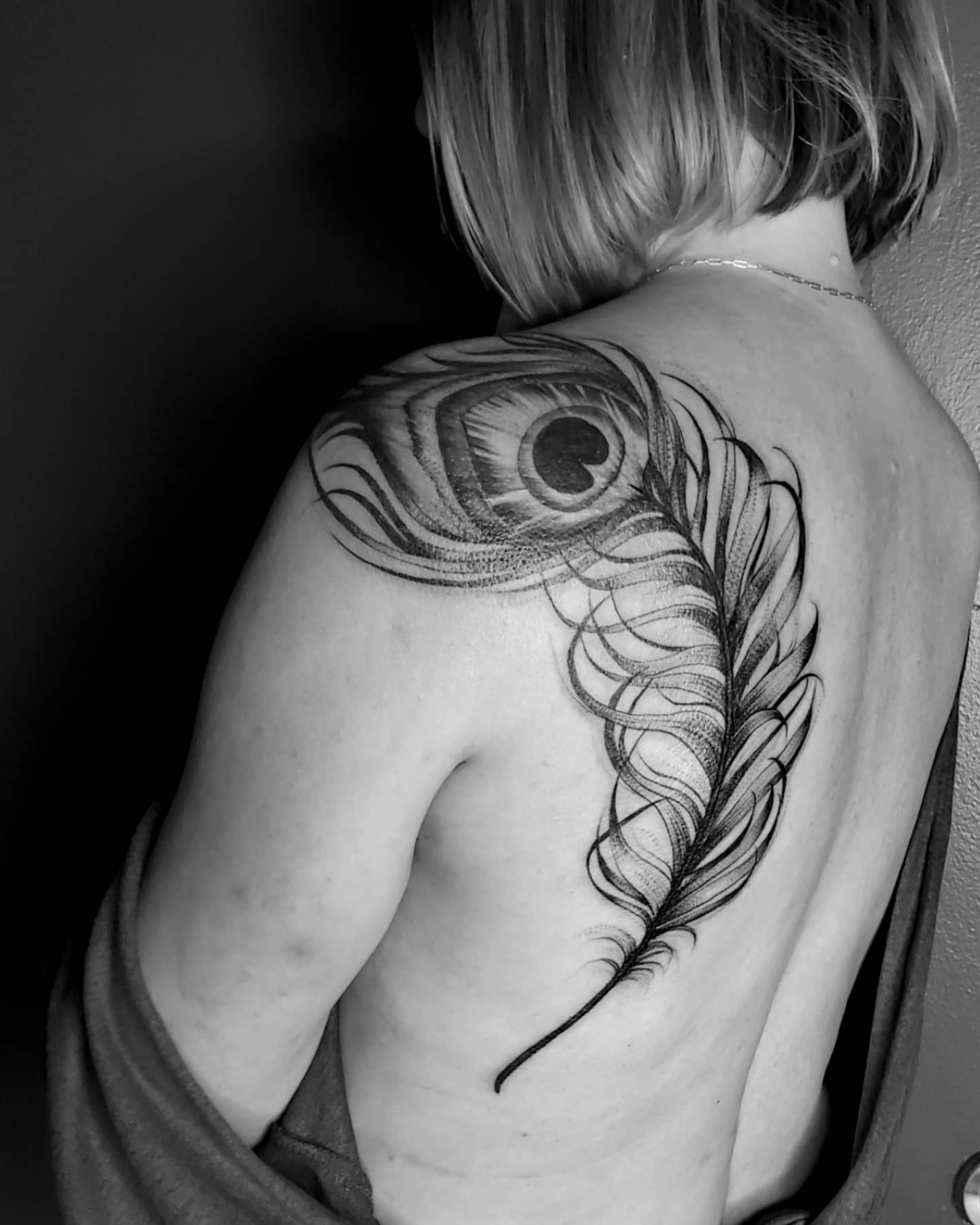 Peacock feather dotwork tattoo on the shoulder by Neil Ohmie