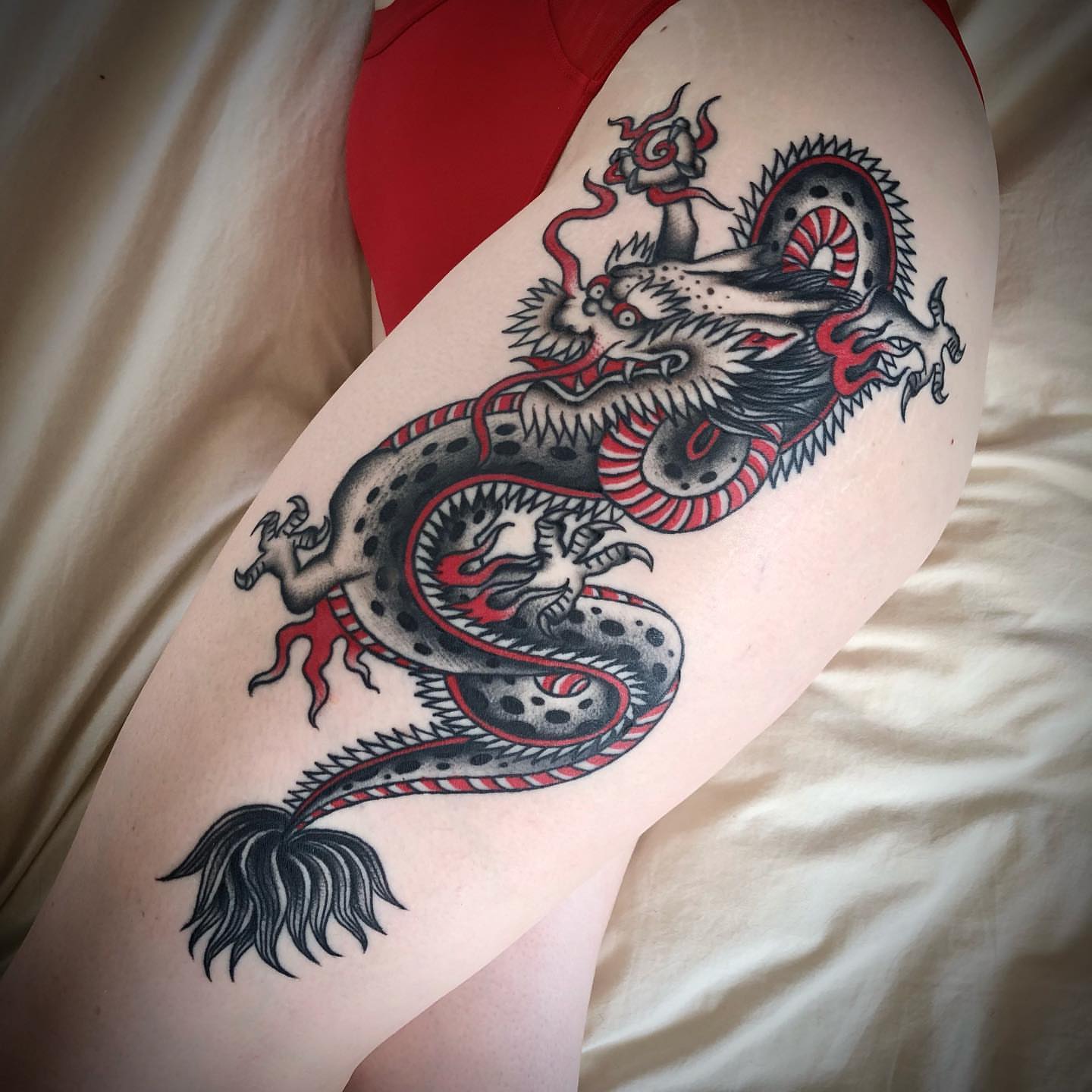 Dragon American traditional tattoo on the thigh by Paul Trimble