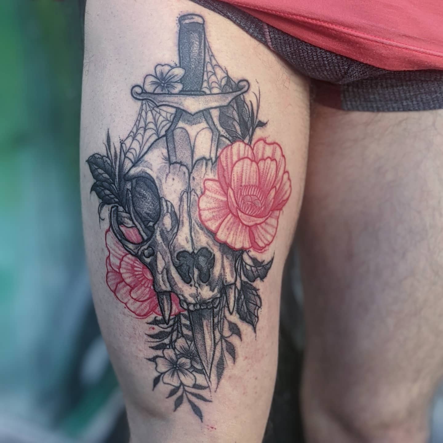 Skull and flowers realism tattoo on the thigh by Gail Howard Perry III