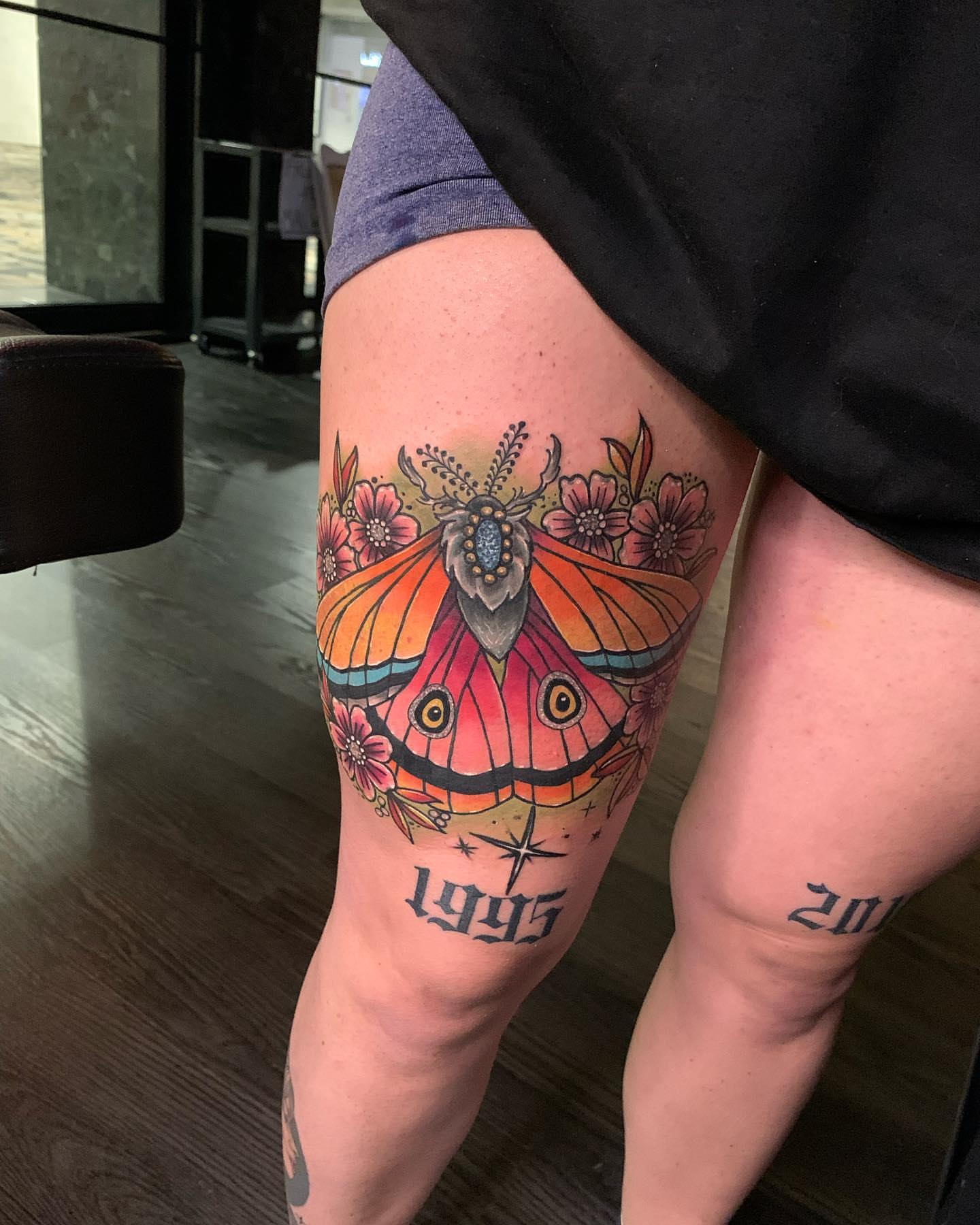 Moth and flowers watercolor tattoo on the thigh by Seth Scott