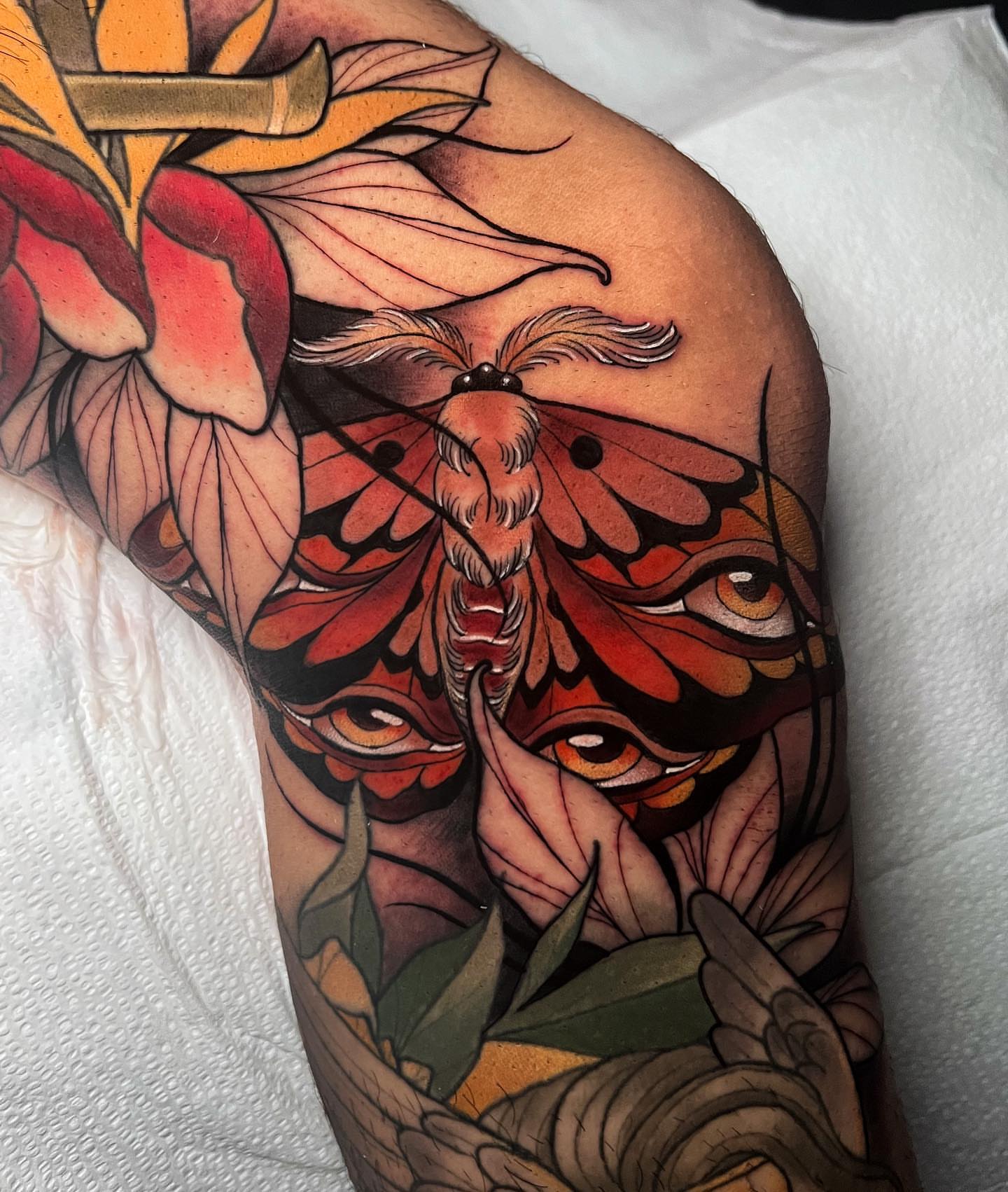 Moth and flower realism tattoo on the upper arm by π·πΉππππ π²πππππ·