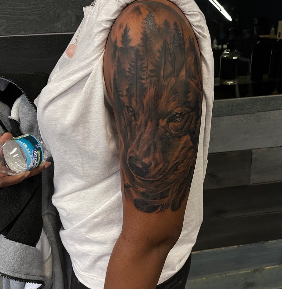 Wolf realism tattoo on the upper arm by Mikeyftsk2