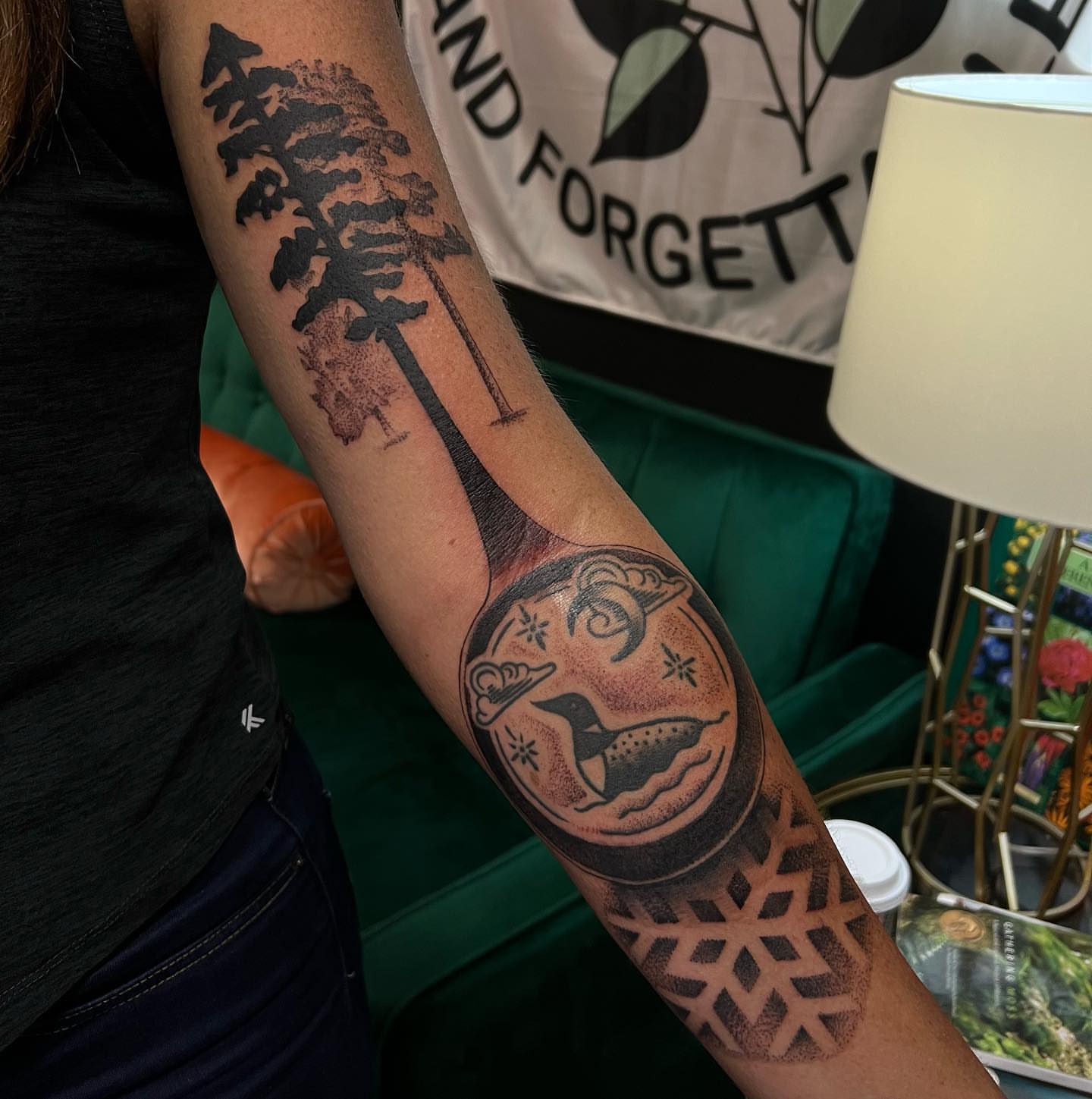 Pine tree and loon geometric tattoo on the forearm by Ałex, Portland, Oregon