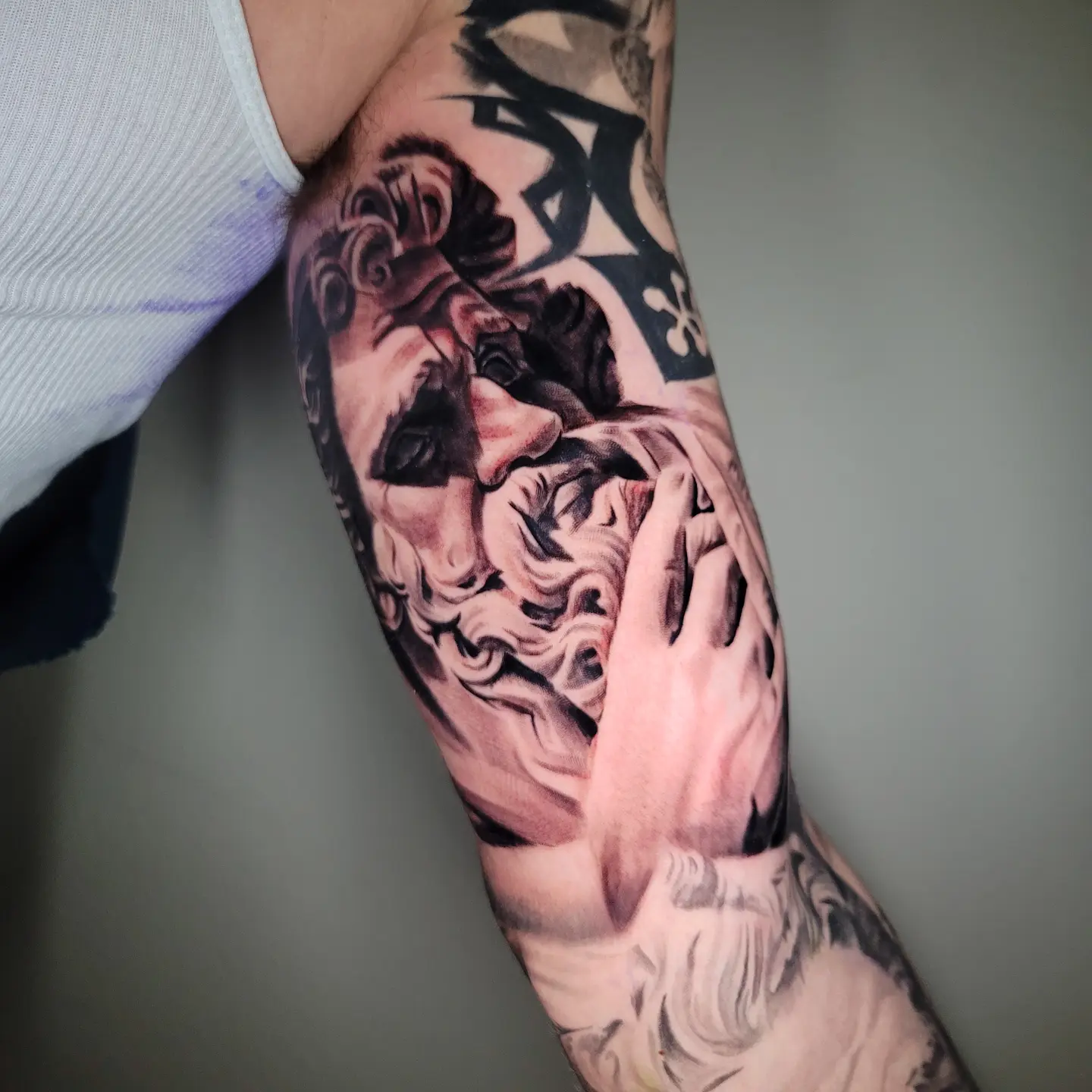 Man's face realism tattoo on the forearm by Angel Lizarraga
