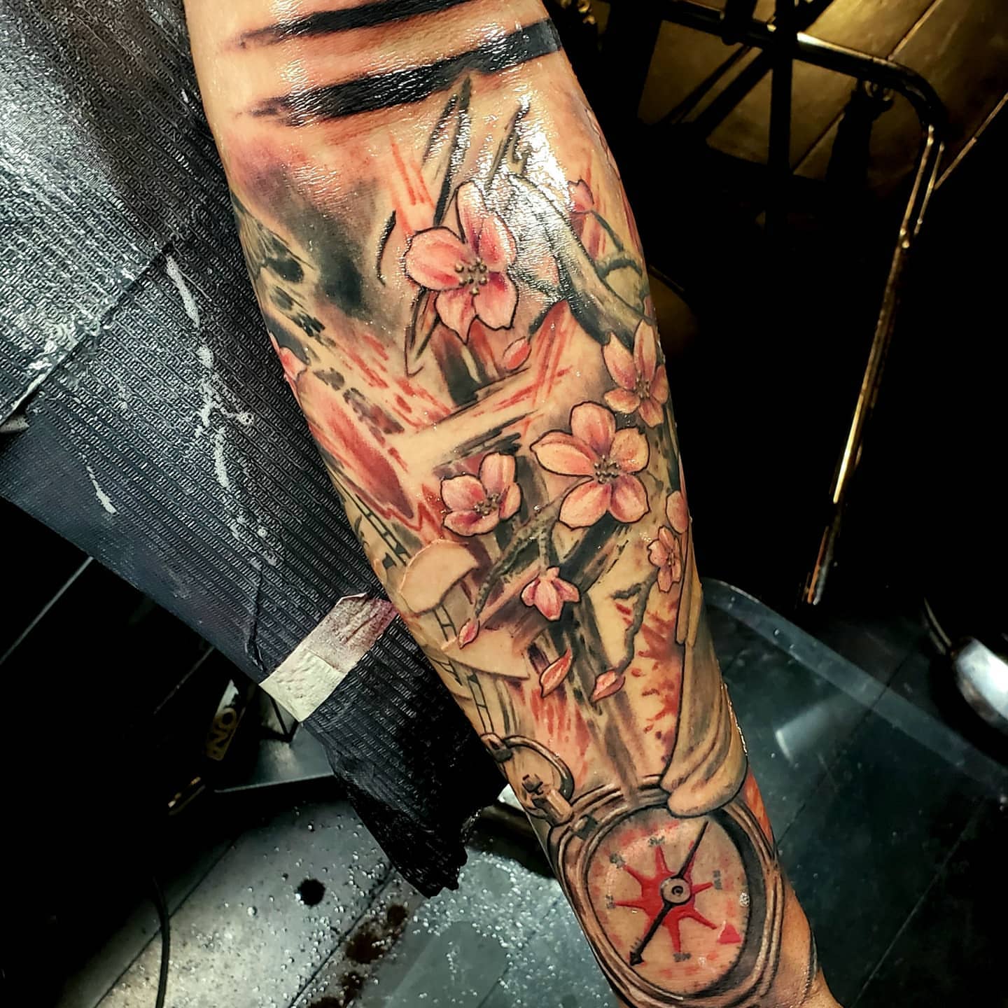 Cherry blossoms and compass realism tattoo on the forearm by Jake Goss, Salt Lake City, Utah