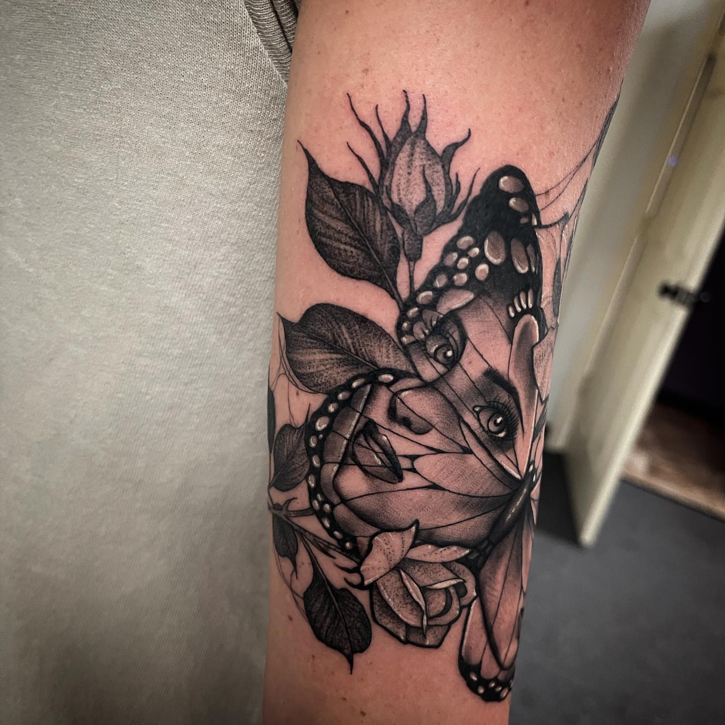 Butterfly and roses realism tattoo on the forearm by Dale DeVille
