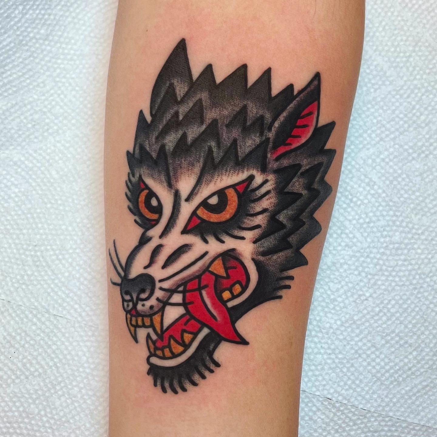 Wolf head American traditional tattoo on the forearm by David Mendieta