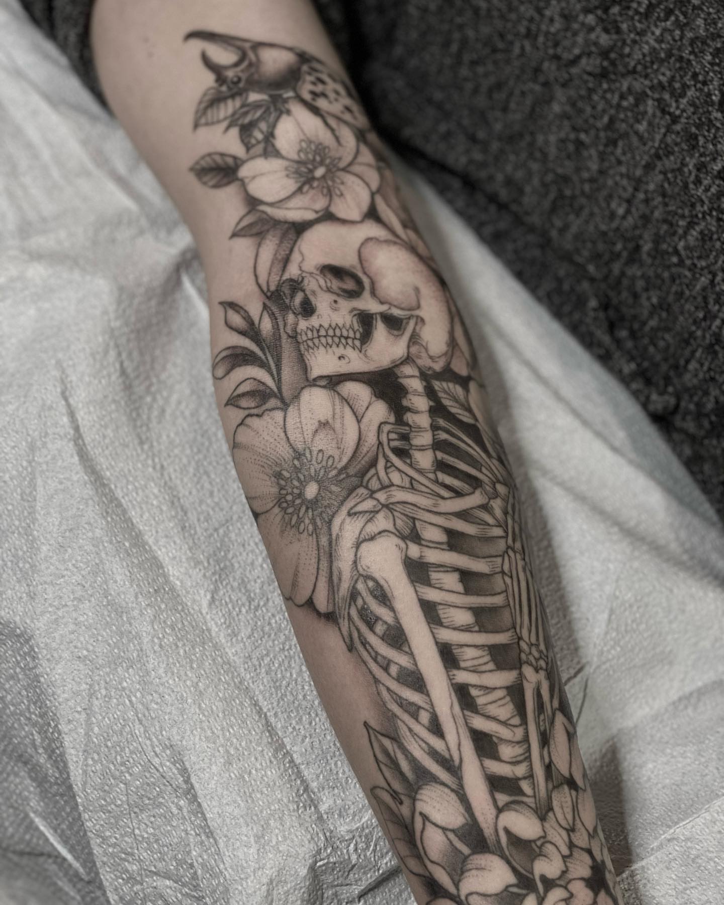 Skeleton with flowers realism tattoo on the forearm by Sam Fortney, Columbus, Ohio