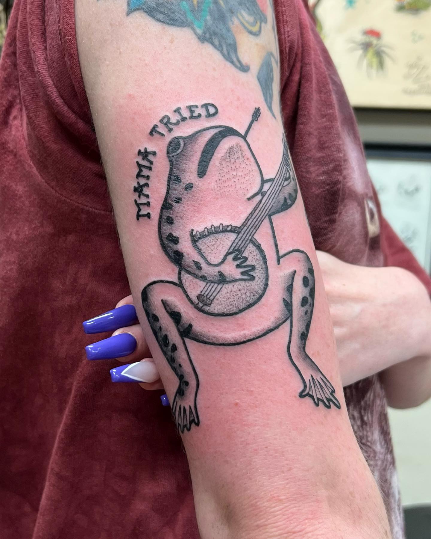Frog playing guitar black and grey tattoo on the forearm by Ałex, Portland, Oregon