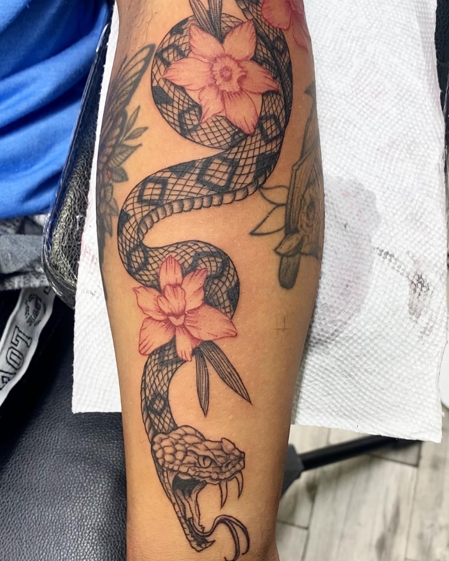 Snake and flowers American traditional tattoo on the forearm by Monique Ortiz, Mesa, Arizona
