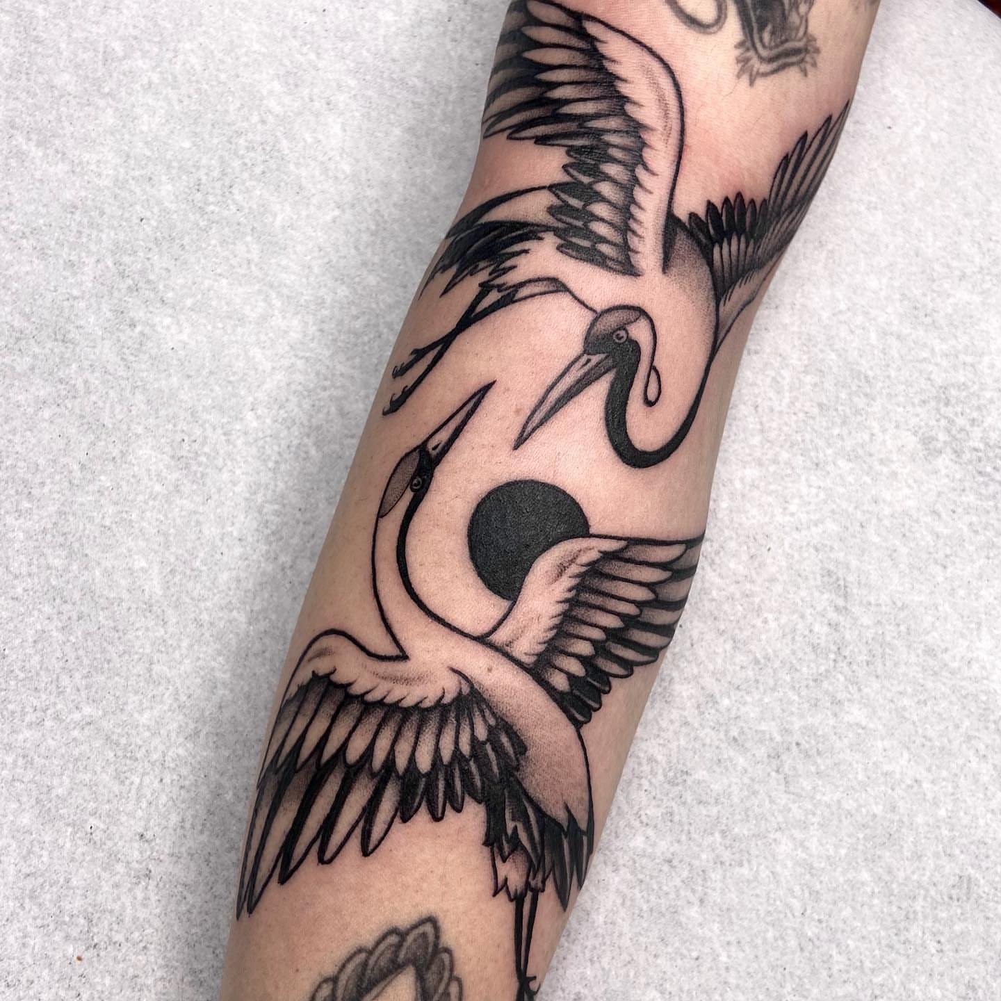 Cranes black and grey tattoo on the forearm by Bruna Bianculli