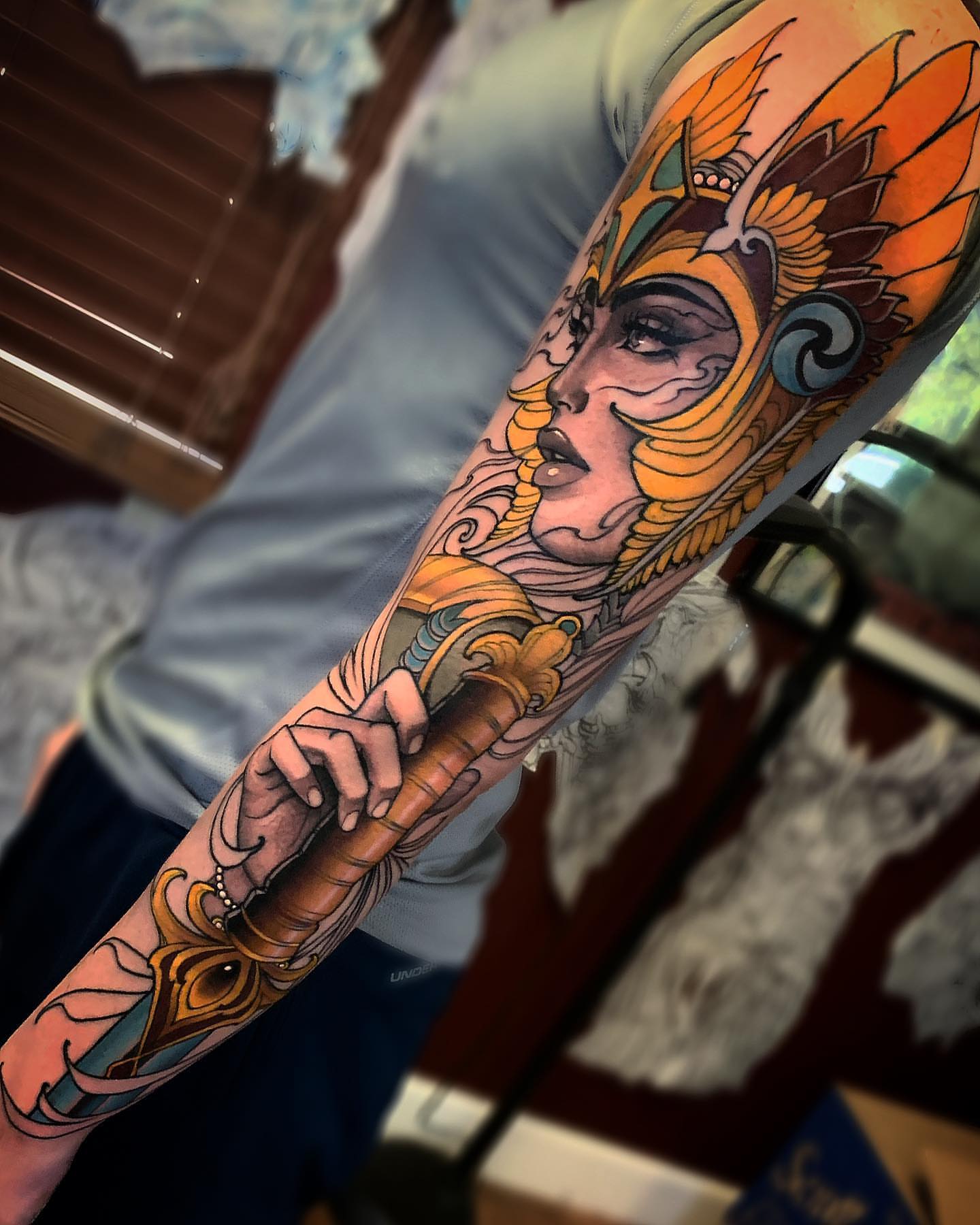 Woman with mask illustrative tattoo on the forearm by Jeff Norton, Atascadero, California