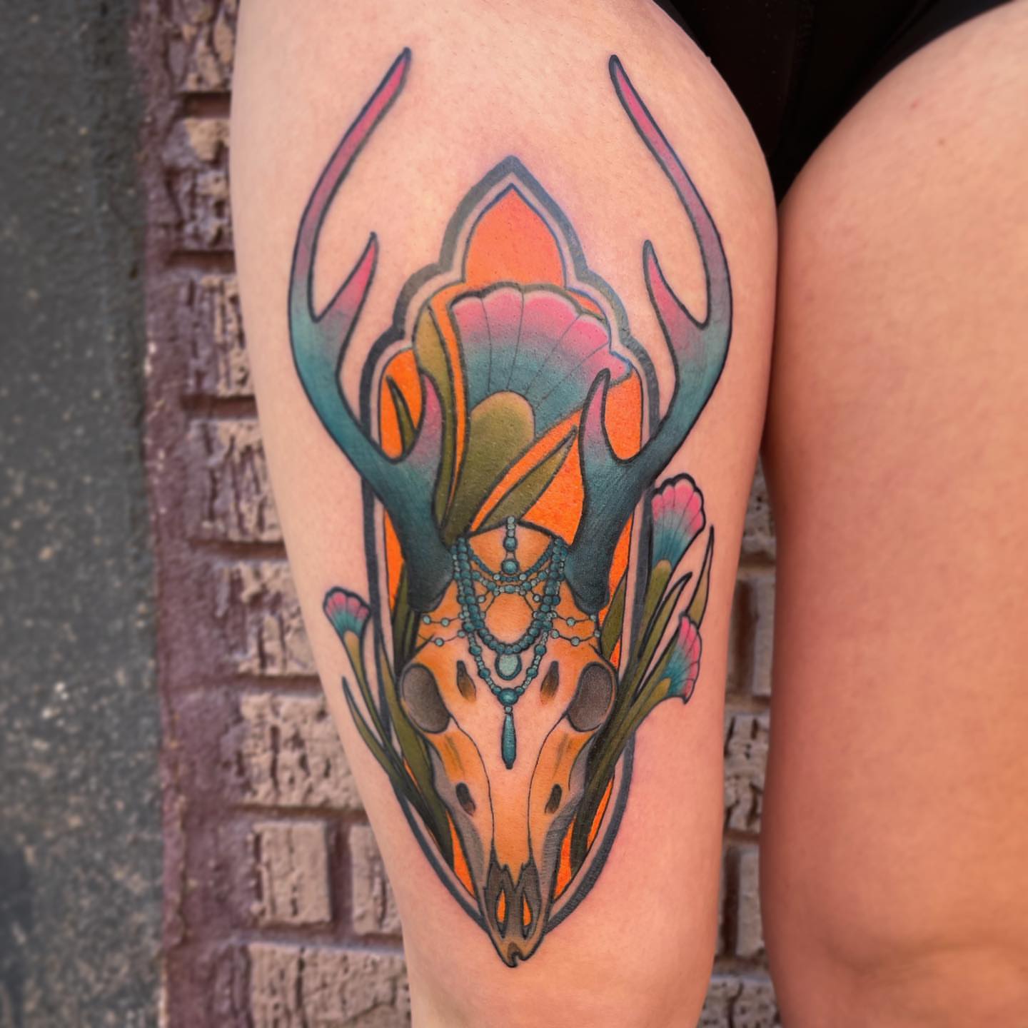 Deer skull with floral elements new school tattoo on the thigh by Ben Viamontes