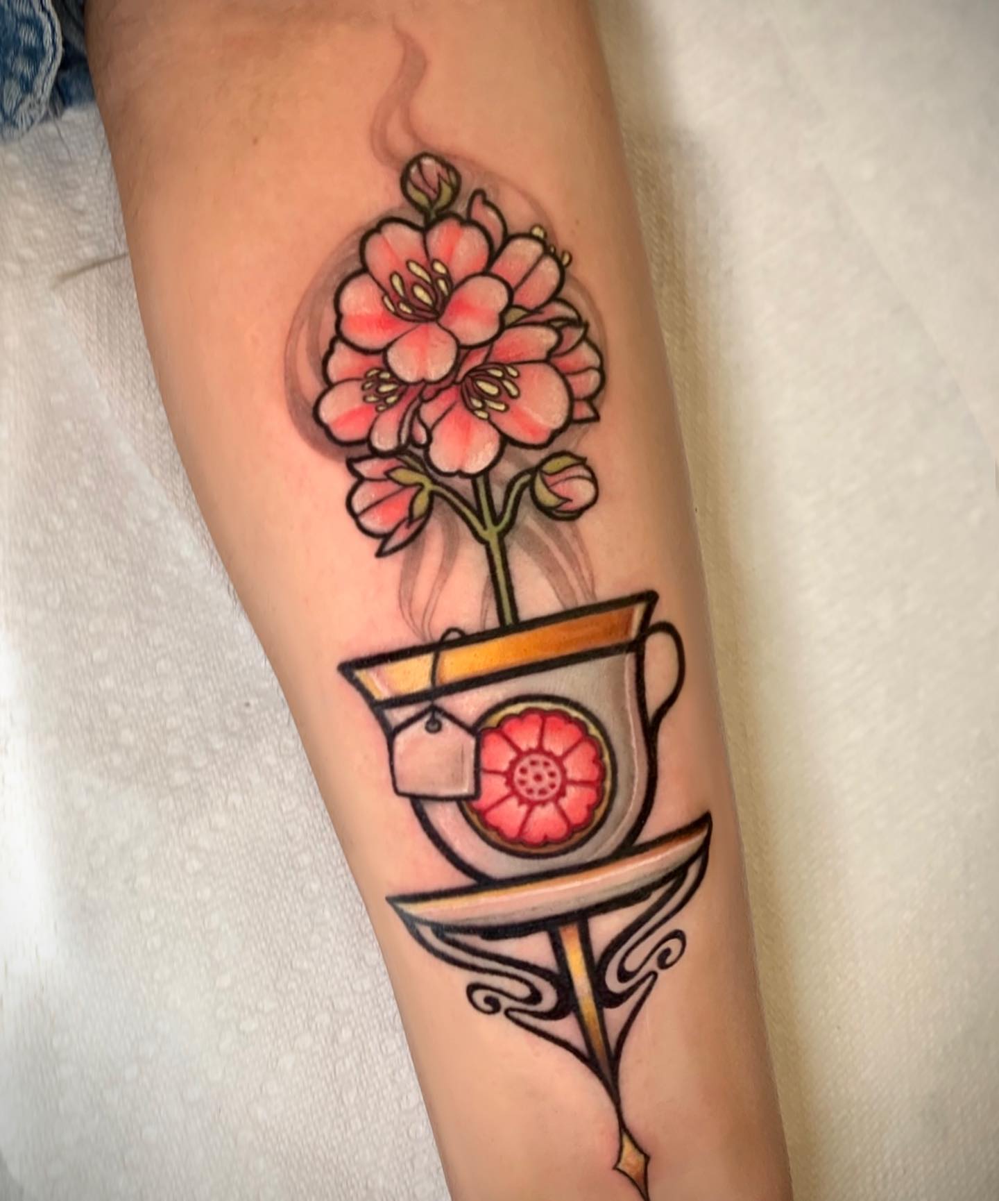 Flower in teacup American traditional tattoo on the forearm by Cortney Norton