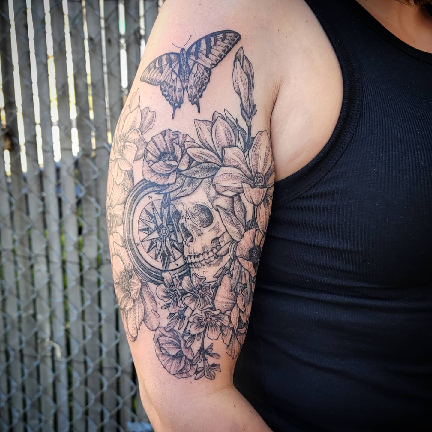 Skull with flowers and compass realism tattoo on the upper arm by Shar - Utah Tattoo Artist