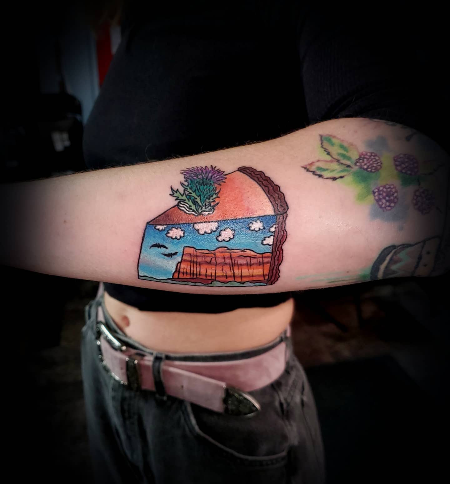 Landscape cake illustrative tattoo on the forearm by Jack Daniel Knowlden