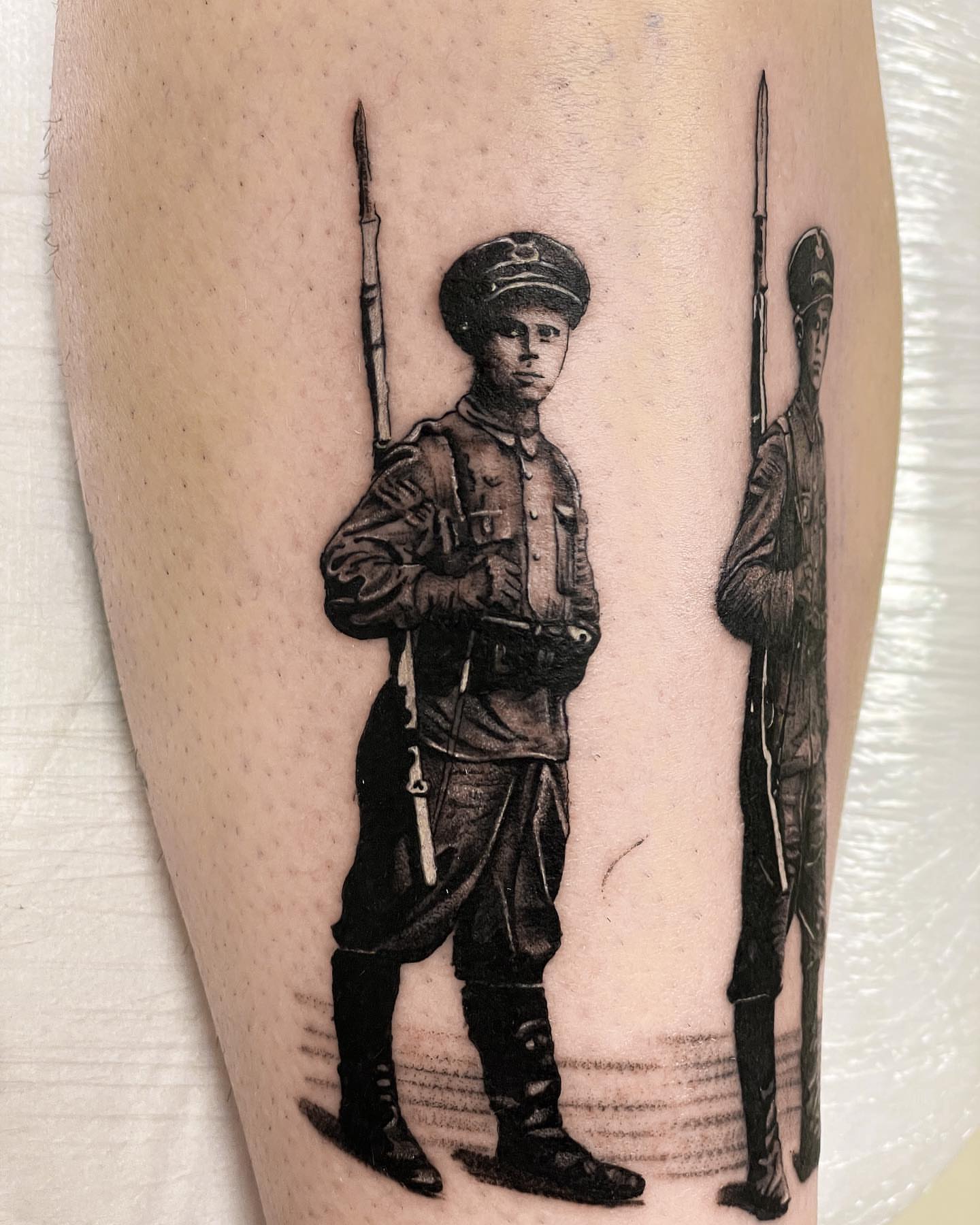 Soldiers black and grey tattoo on the leg by Iryna Polyakhova