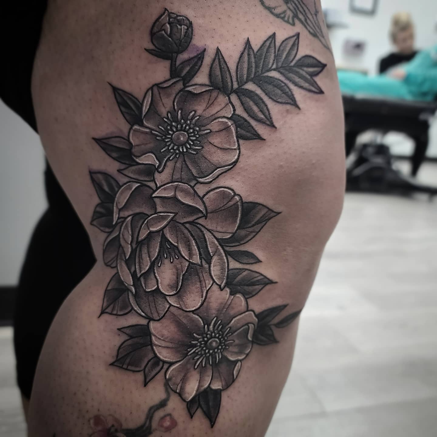 Flowers black and grey tattoo on the thigh by Elidia Veliz