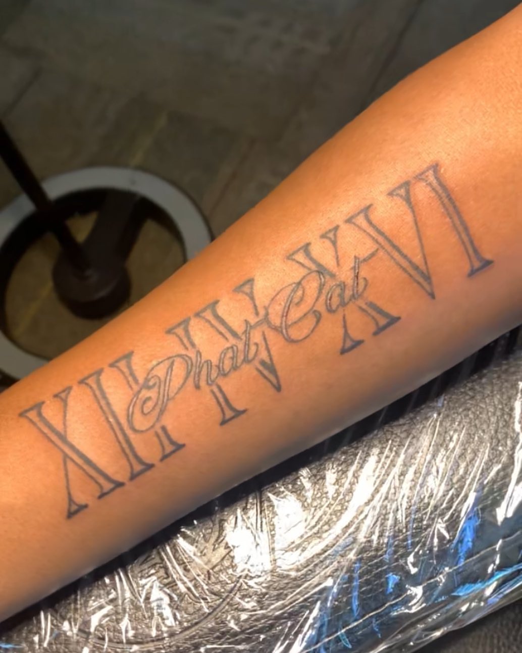 Roman numerals and script lettering script tattoo on the forearm by Wichita Tattoo
