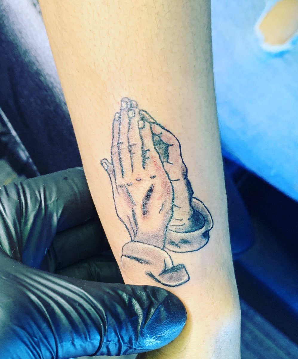 Praying hands black and grey tattoo on the forearm by Wichita Tattoo