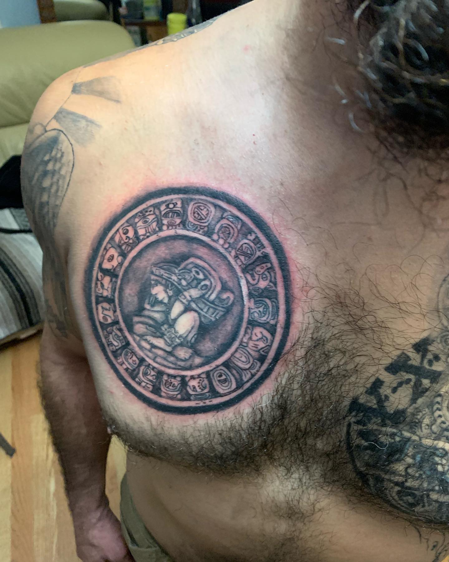Astronomical calendar black and grey tattoo on the chest by Daniel Illachek