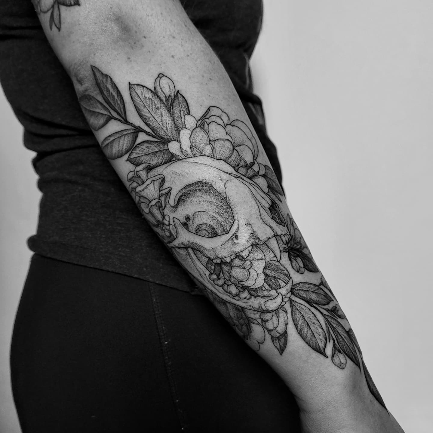 Skull and flowers dotwork tattoo on the forearm by Matthew Barnett
