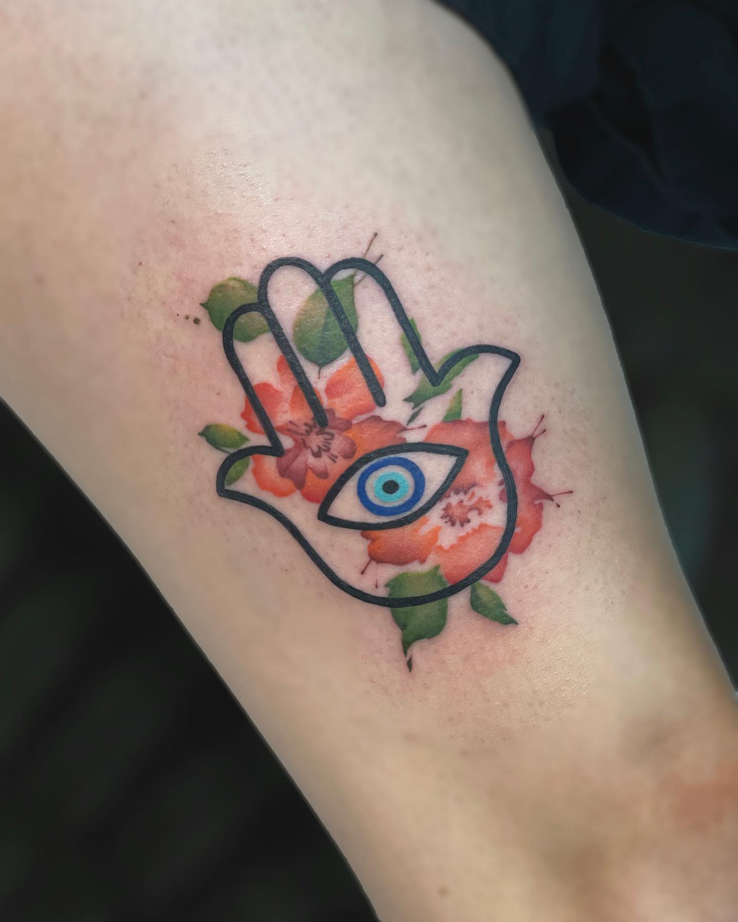 Hamsa hand with eye and flowers watercolor tattoo on the forearm by Georgia Grey