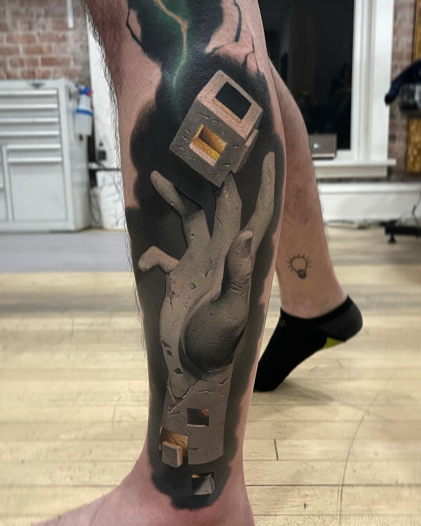 Hand with floating cube realism tattoo on the calf by Jacob Sheffield, Grand Junction, Colorado
