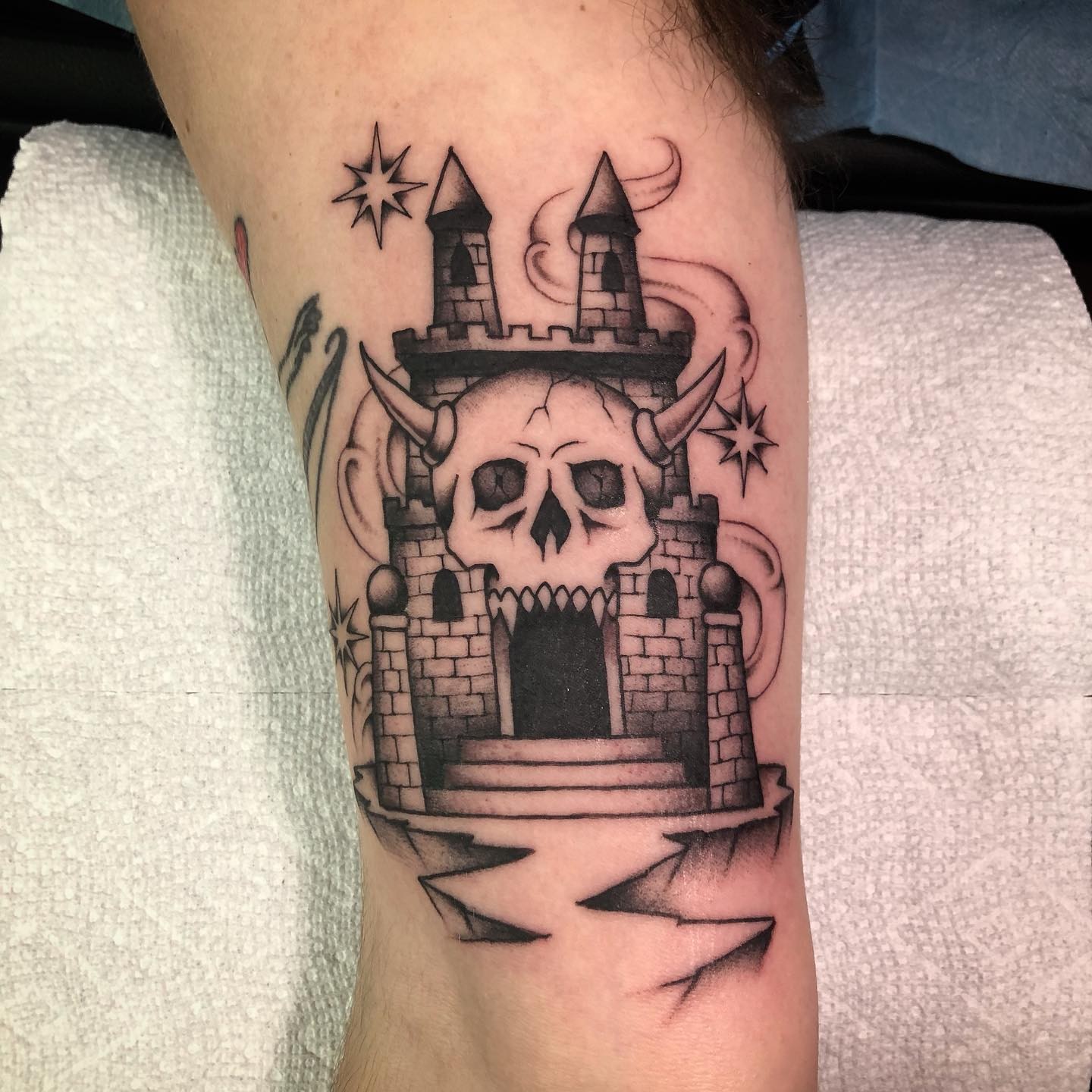 Castle with skull black and grey tattoo on the forearm by Paul Trimble