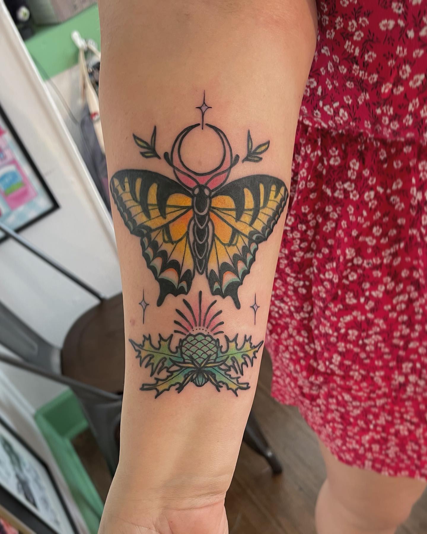 Butterfly and thistle American traditional tattoo on the forearm by Erin Miller