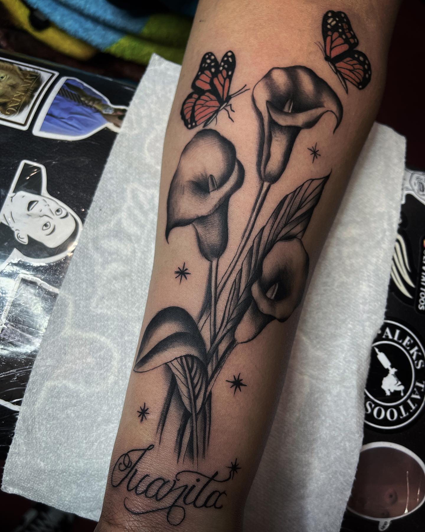 Calla lilies and butterflies black and grey tattoo on the forearm by Las Vegas Tattoo Artist