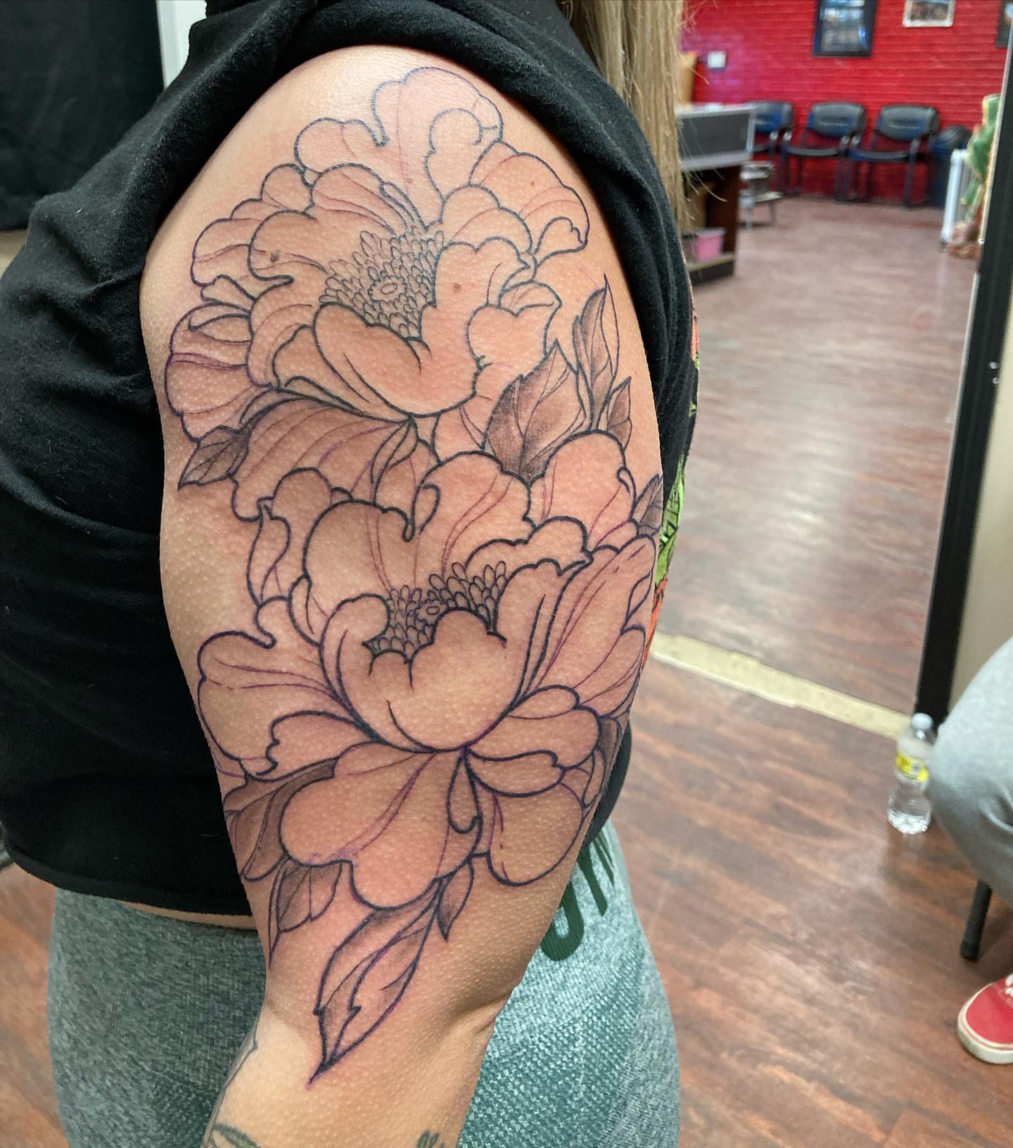 Peony flowers black and grey tattoo on the upper arm by Chuck House