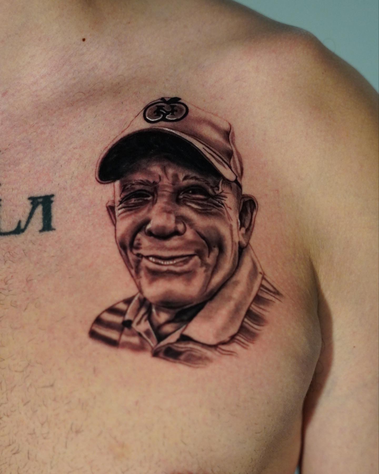 Portrait of a smiling man realism tattoo on the chest by Adrian Dominguez, Las Vegas, Nevada