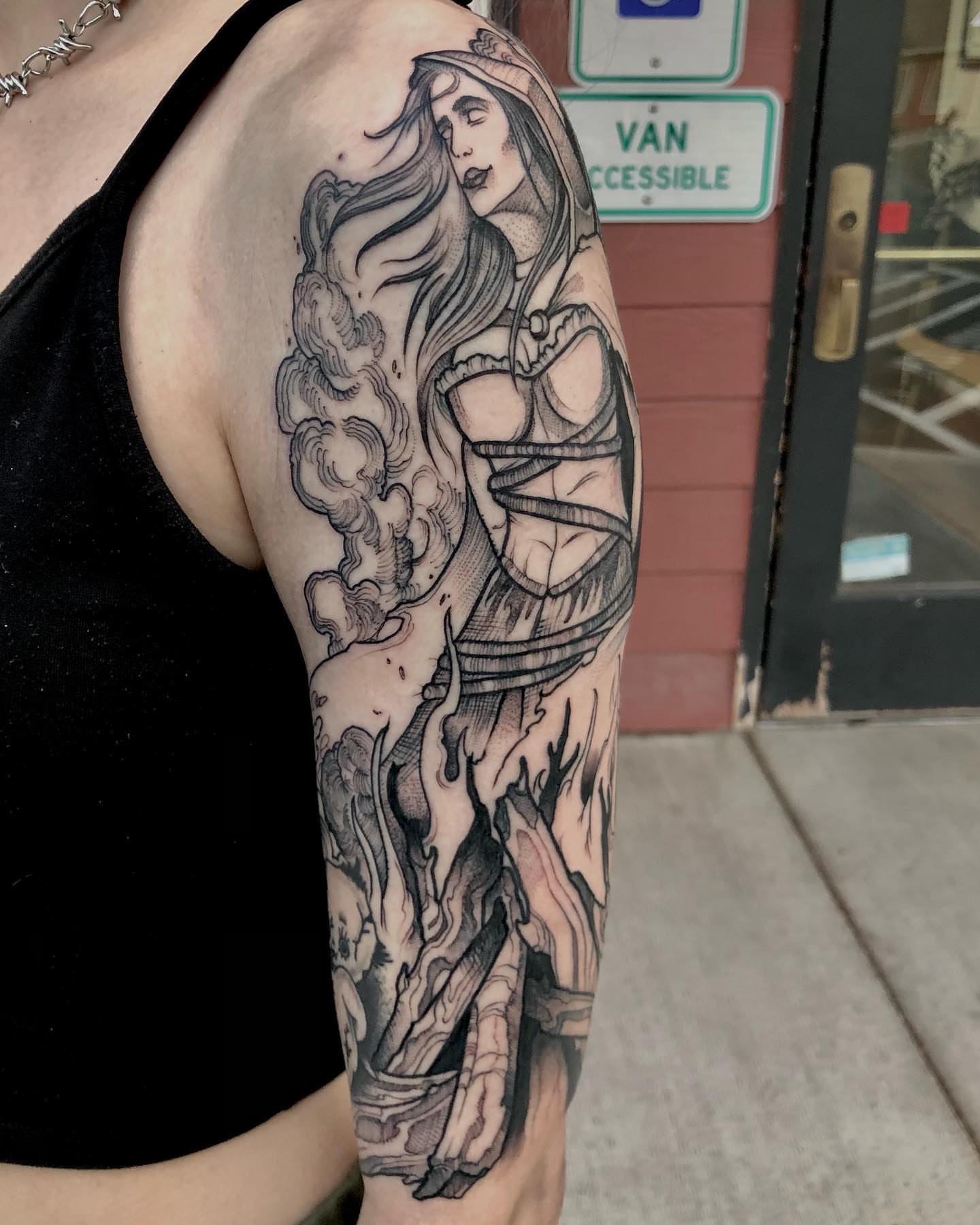 Woman with flowing hair realism tattoo on the upper arm by Aaron Borden